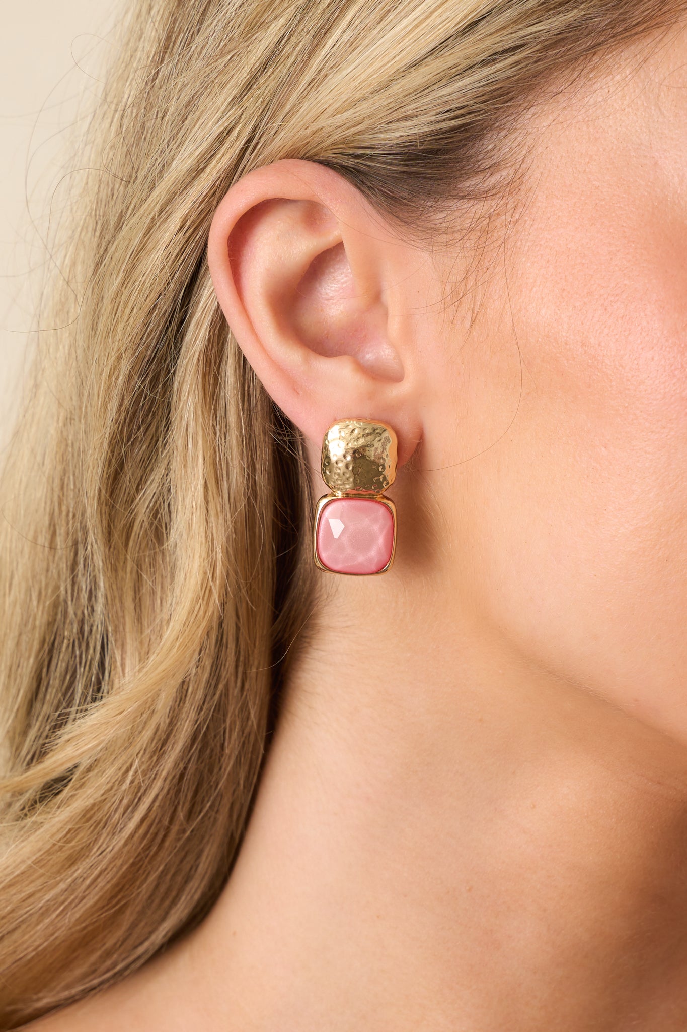 Front view of the earrings showing textured gold square studs and pink square bezel-set gemstones hanging below.