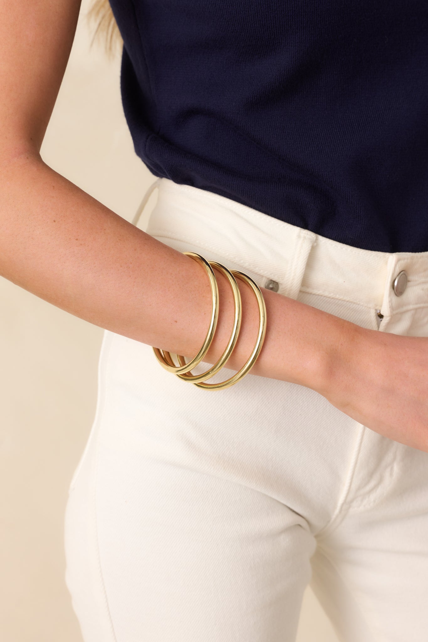 Angled cropped shot highlighting the uniform shape and sleek surface of the rigid bangles.