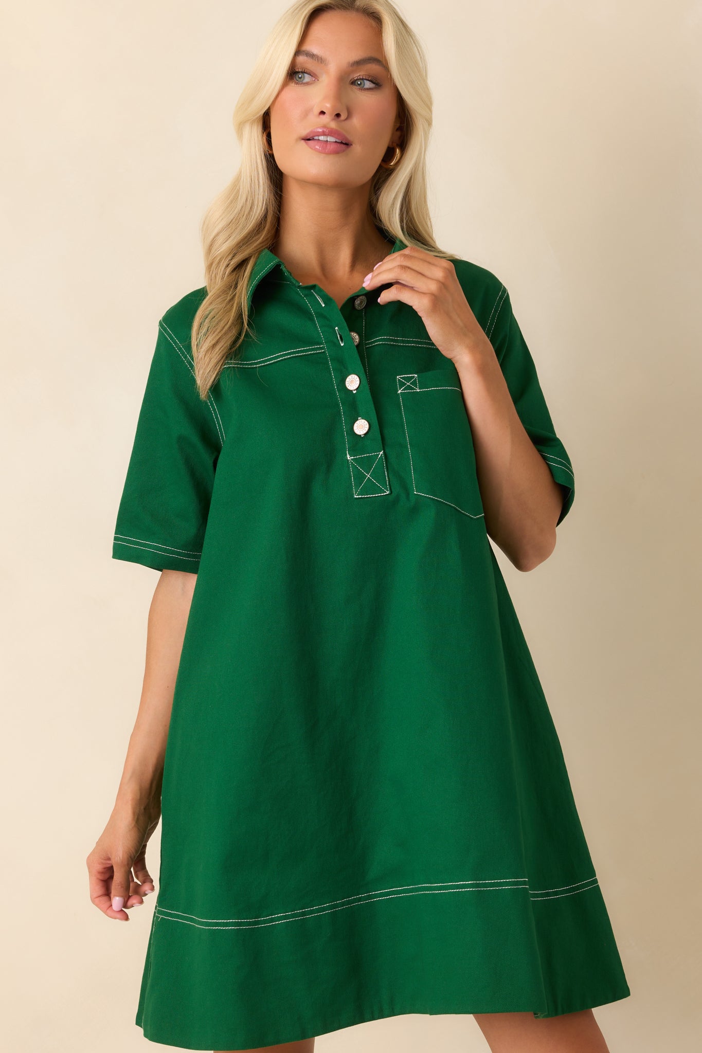 A close cropped view of the collared mini dress emphasizing the bold kelly green fabric and tailored front design.