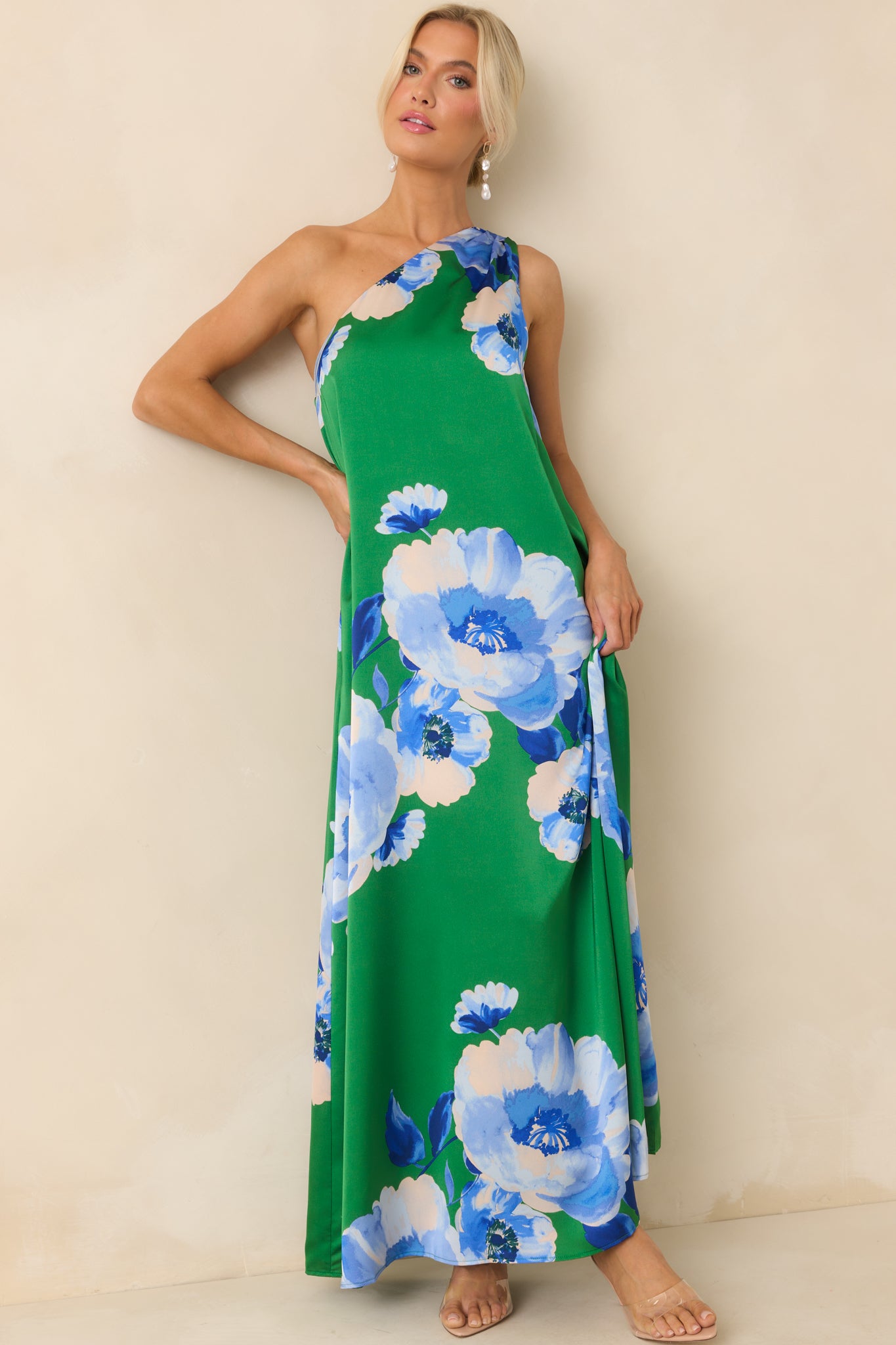 A slightly angled front view emphasizing the asymmetry of the one shoulder neckline and the vibrant blue floral design.