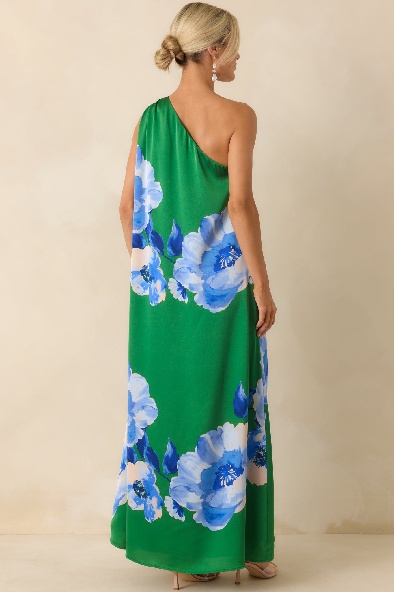 A back view of the green maxi dress featuring the continuation of the floral pattern and smooth satin finish, with full lining subtly visible.