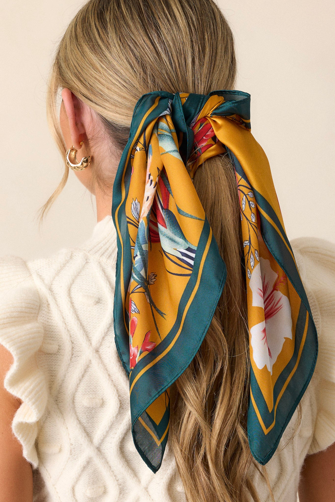 This green floral scarf features a green border and a flower field print.