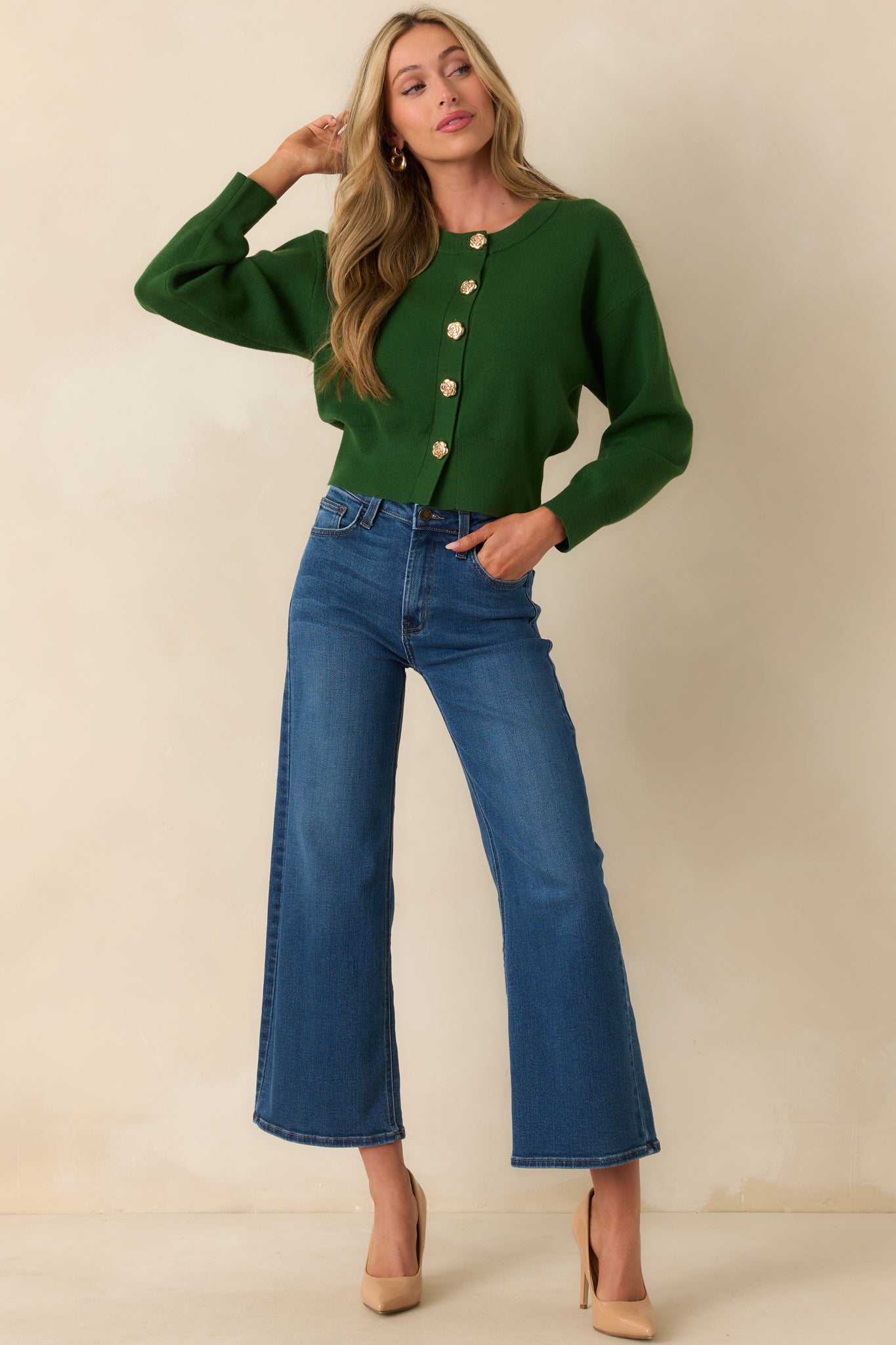 Standing pose displaying the cardigan fully buttoned, highlighting its fitted silhouette and structured ribbed hem.