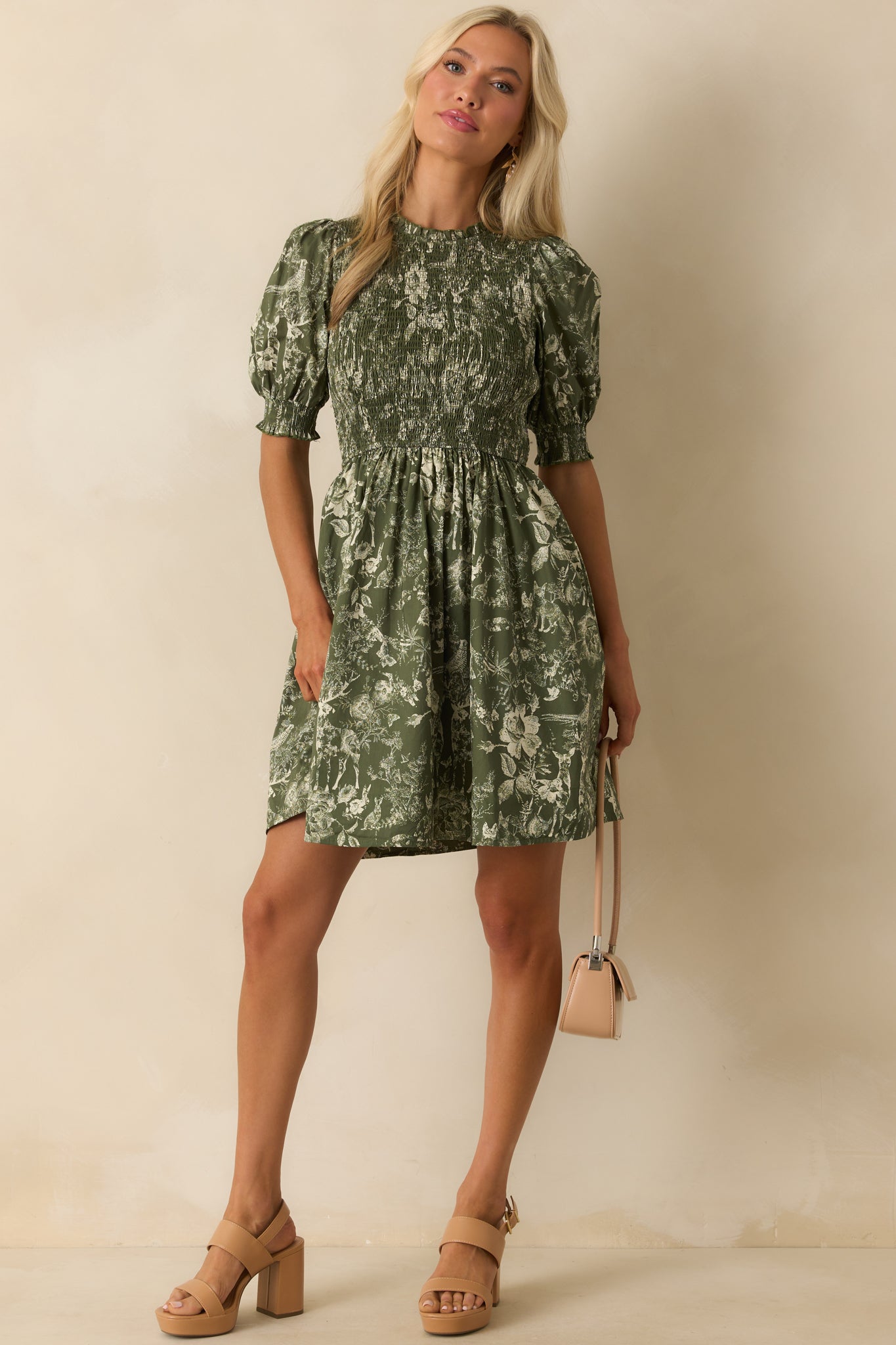 Nature-inspired toile print mini dress in green with fitted smocked bodice and short puff sleeves.