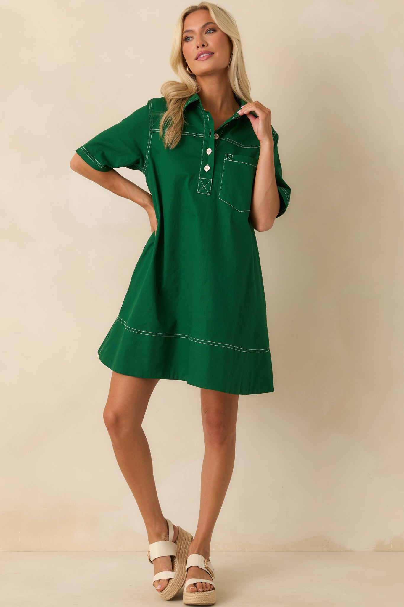 A full body view of the kelly green mini dress featuring a collared neckline and quarter button front with crisp white topstitching.