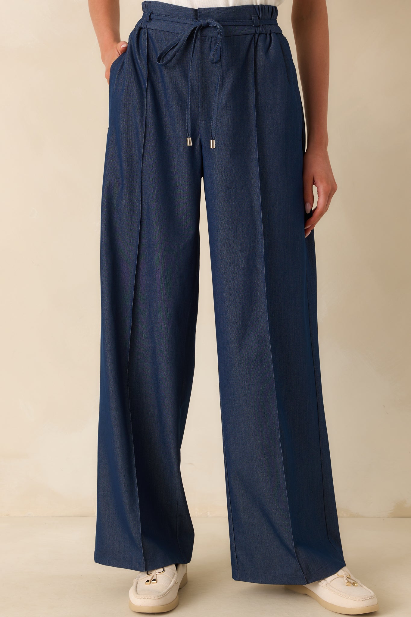 Cropped lower leg view emphasizing the clean lines and seam details down the front of the legs.