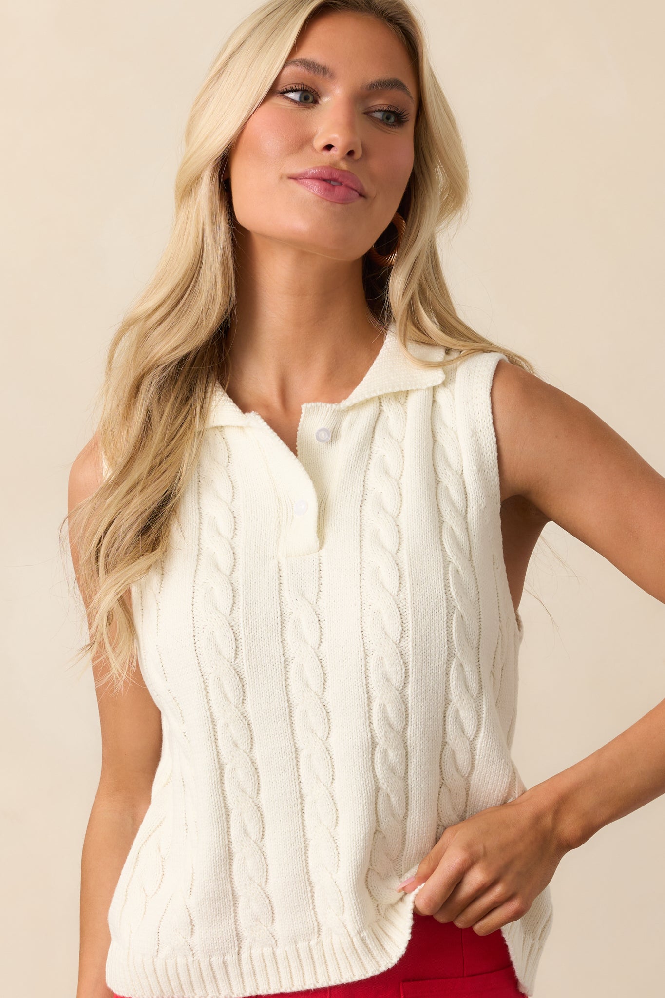 A closer view of the cable knit pattern and ribbed trim along the armhole and hem of the sweater vest.