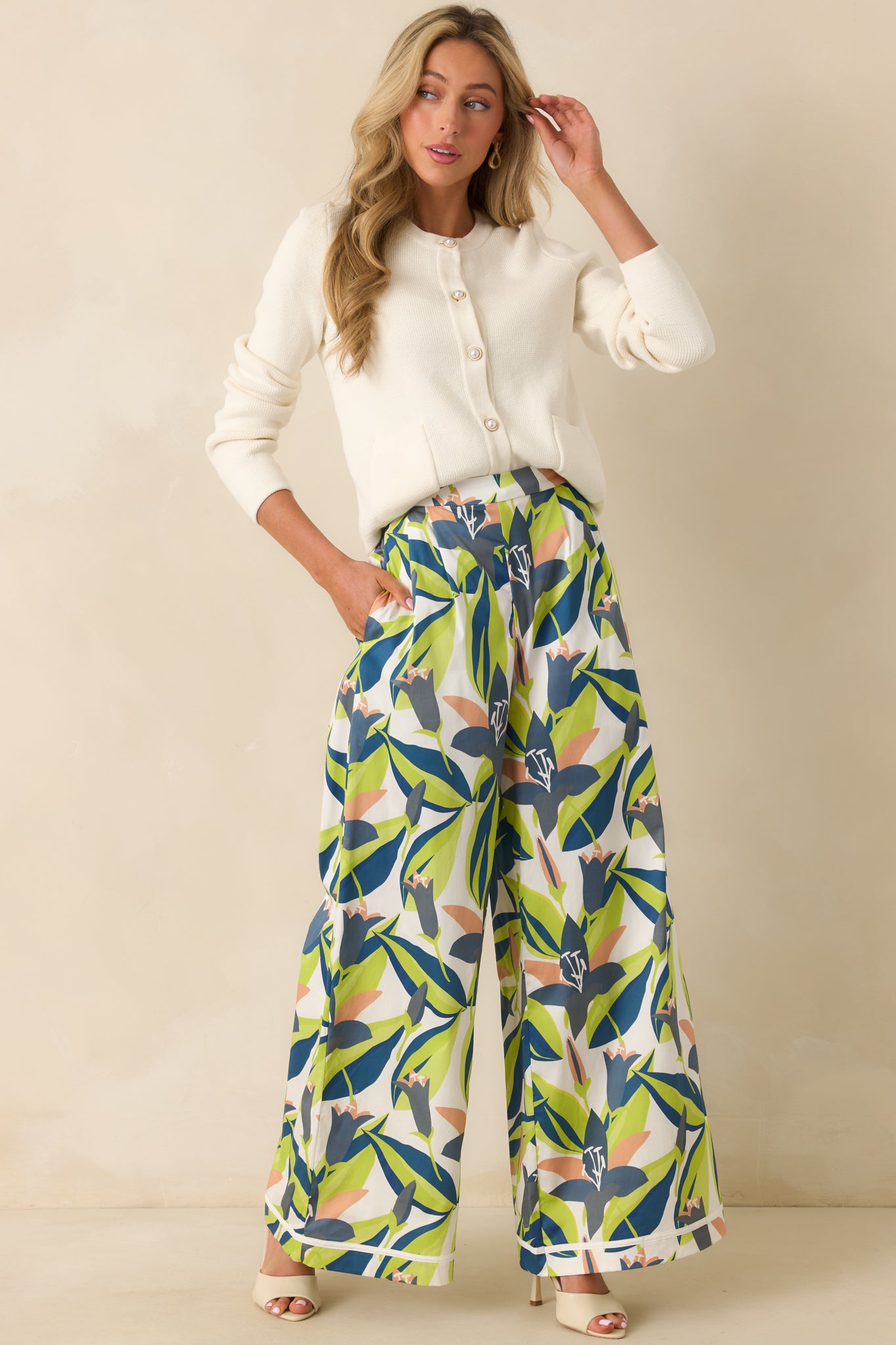 Front view of ivory cotton knit cardigan featuring patch pockets and full-length button closure.