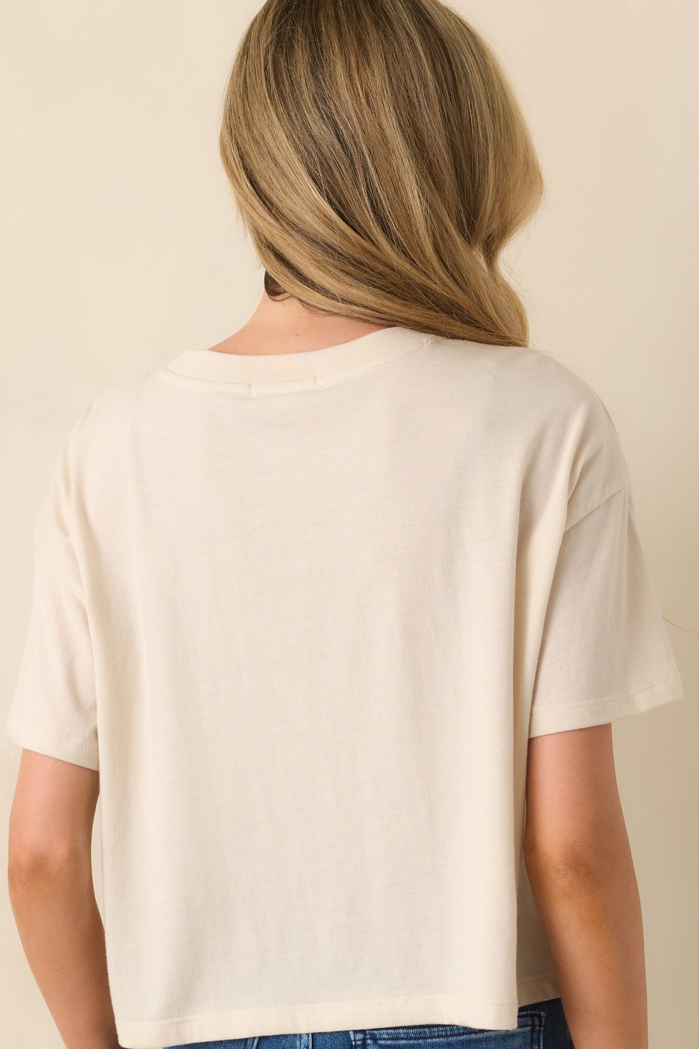 Rear view of ivory cropped tee with classic short sleeve style.