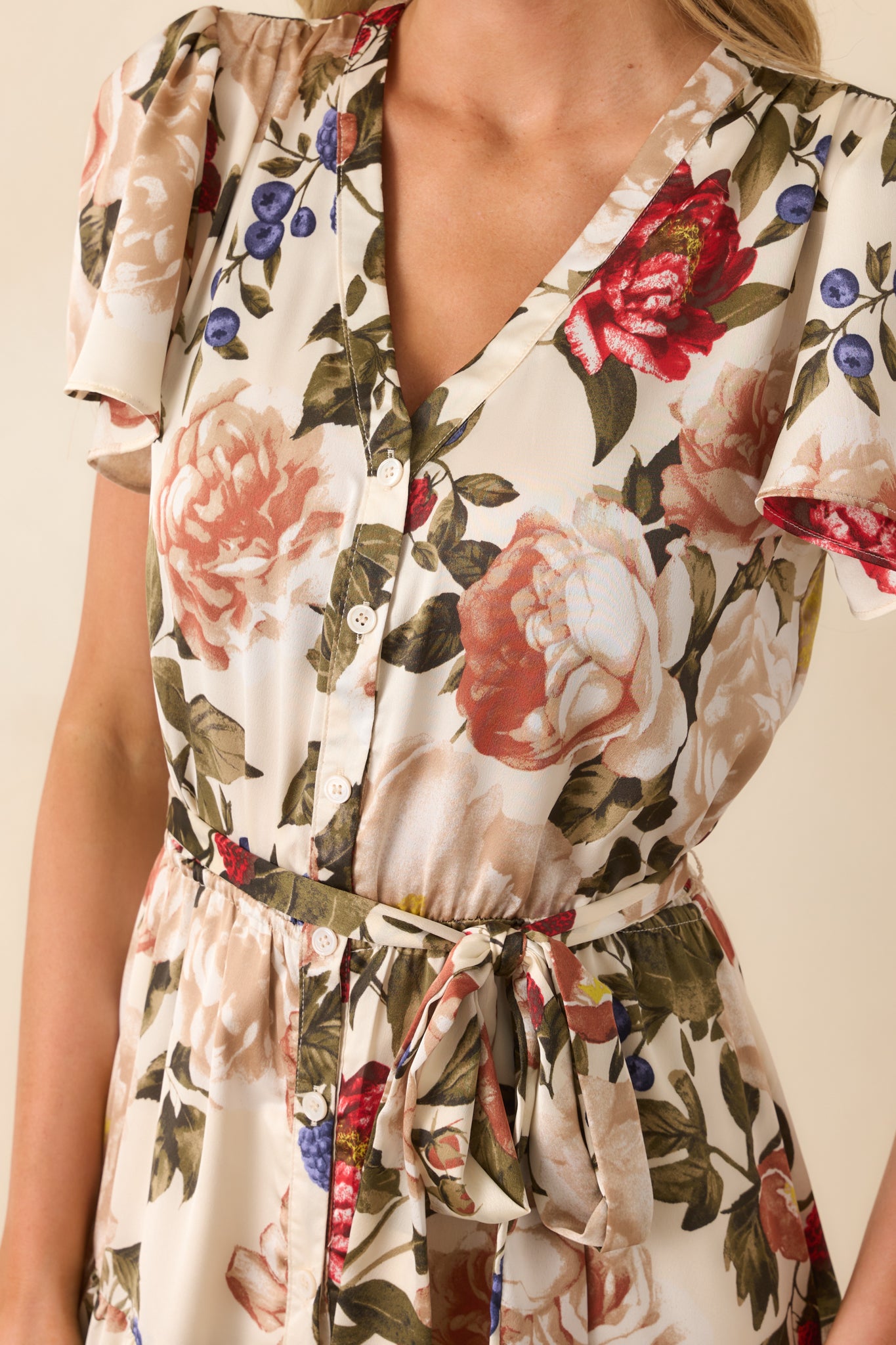 A close-up detail of the functional button front bodice and floral print on the ivory background.