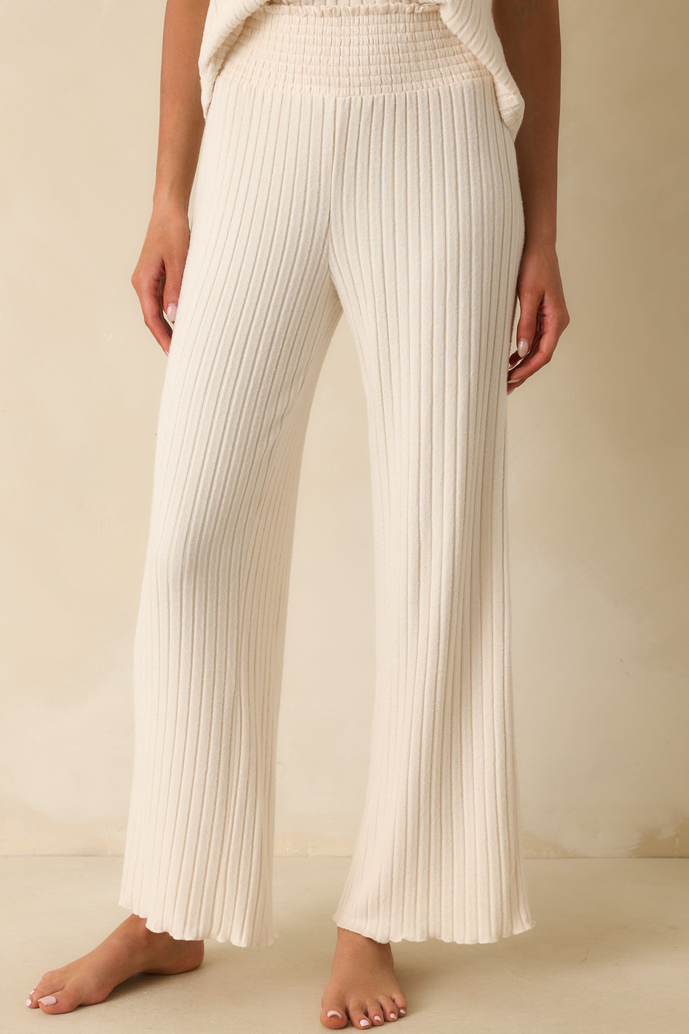 Ivory pants highlighting the wide leg cut and smooth ribbed fabric.
