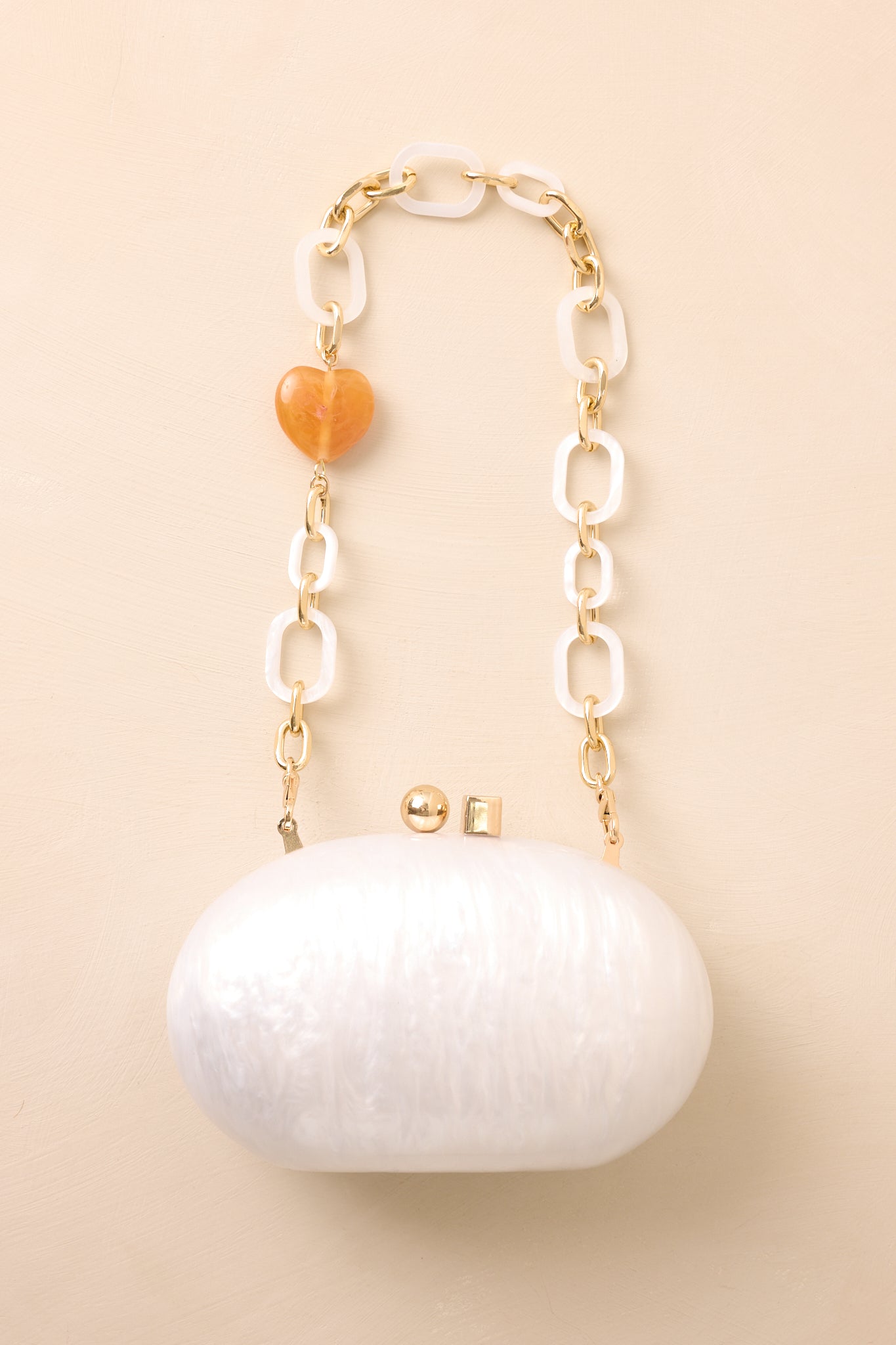 Flat view of the clutch showing detachable resin and gold chain shoulder strap accented with an amber bead.