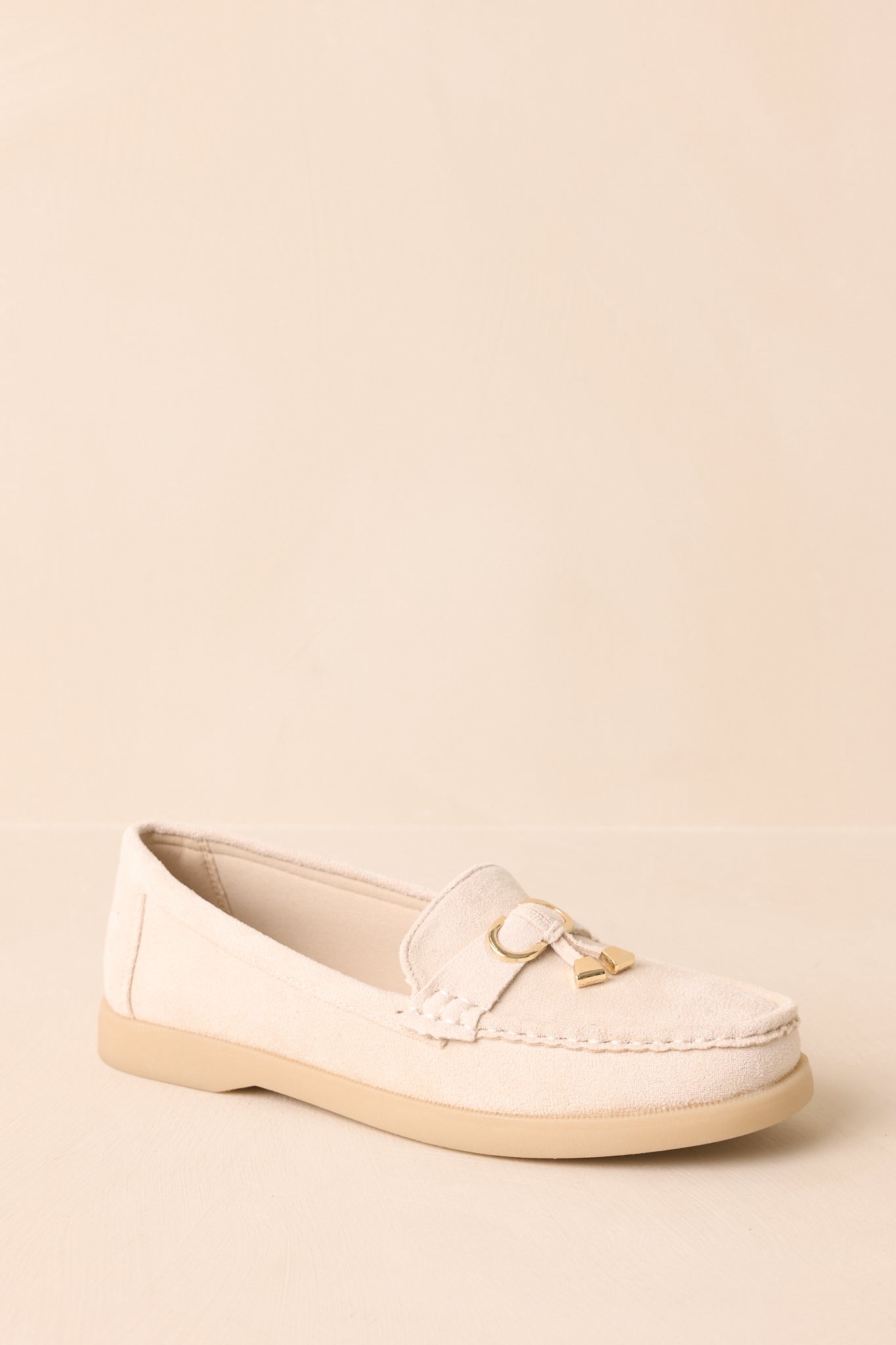 Ivory penny loafers with beige platform sole displayed on beige backdrop at an angle.