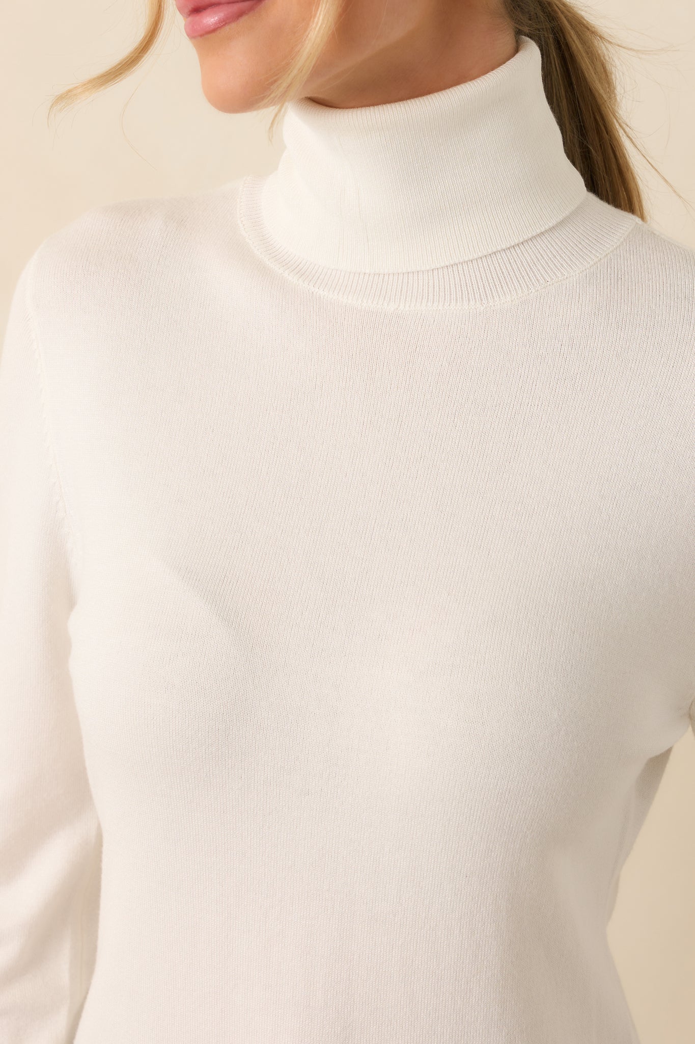 Close-up of the ivory sweater’s knit fabric and ribbed texture, emphasizing its super soft appearance and fine detailing.