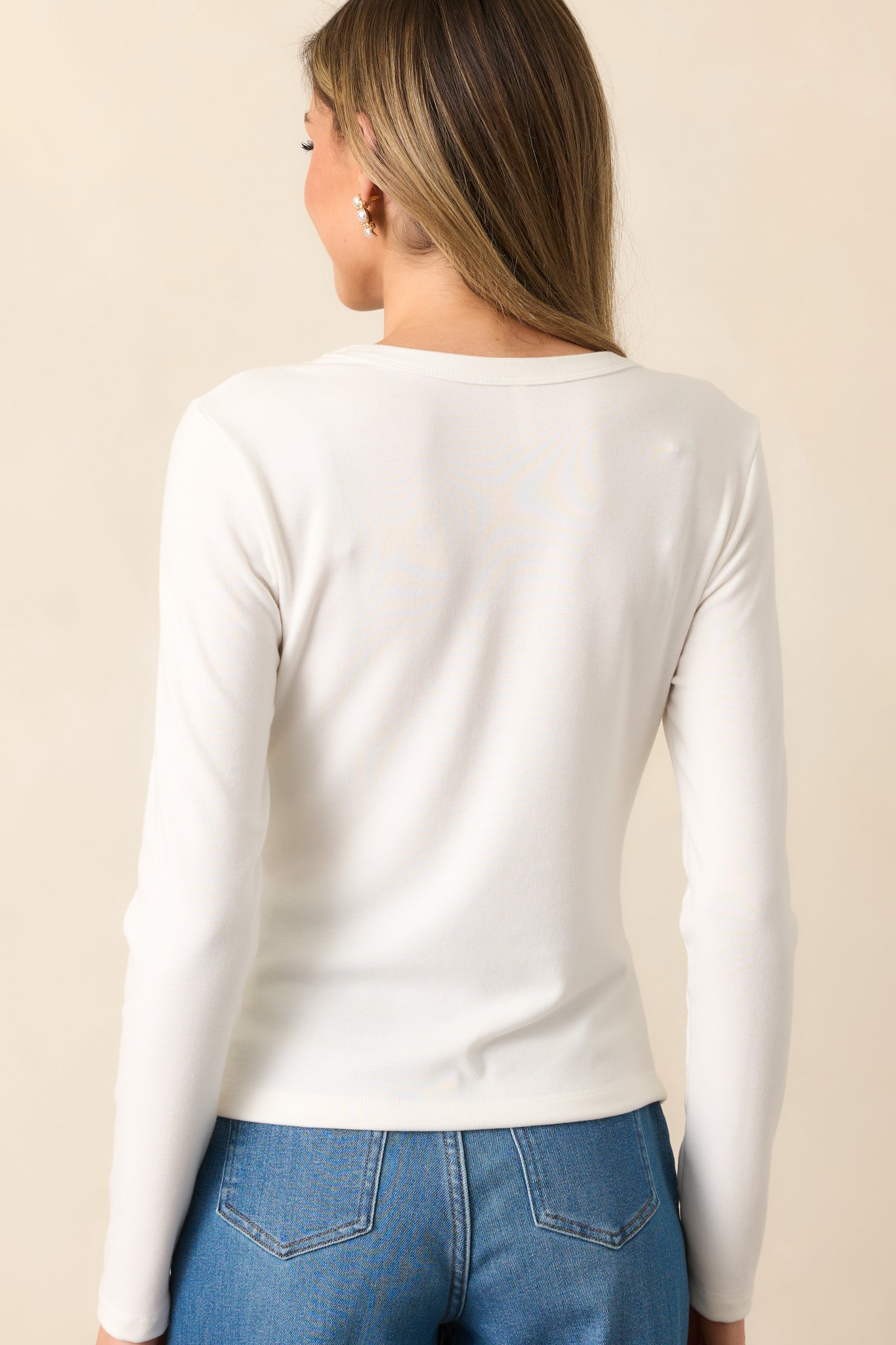 A view from behind of the ivory top, showing the long sleeves and lightly contoured back seam.