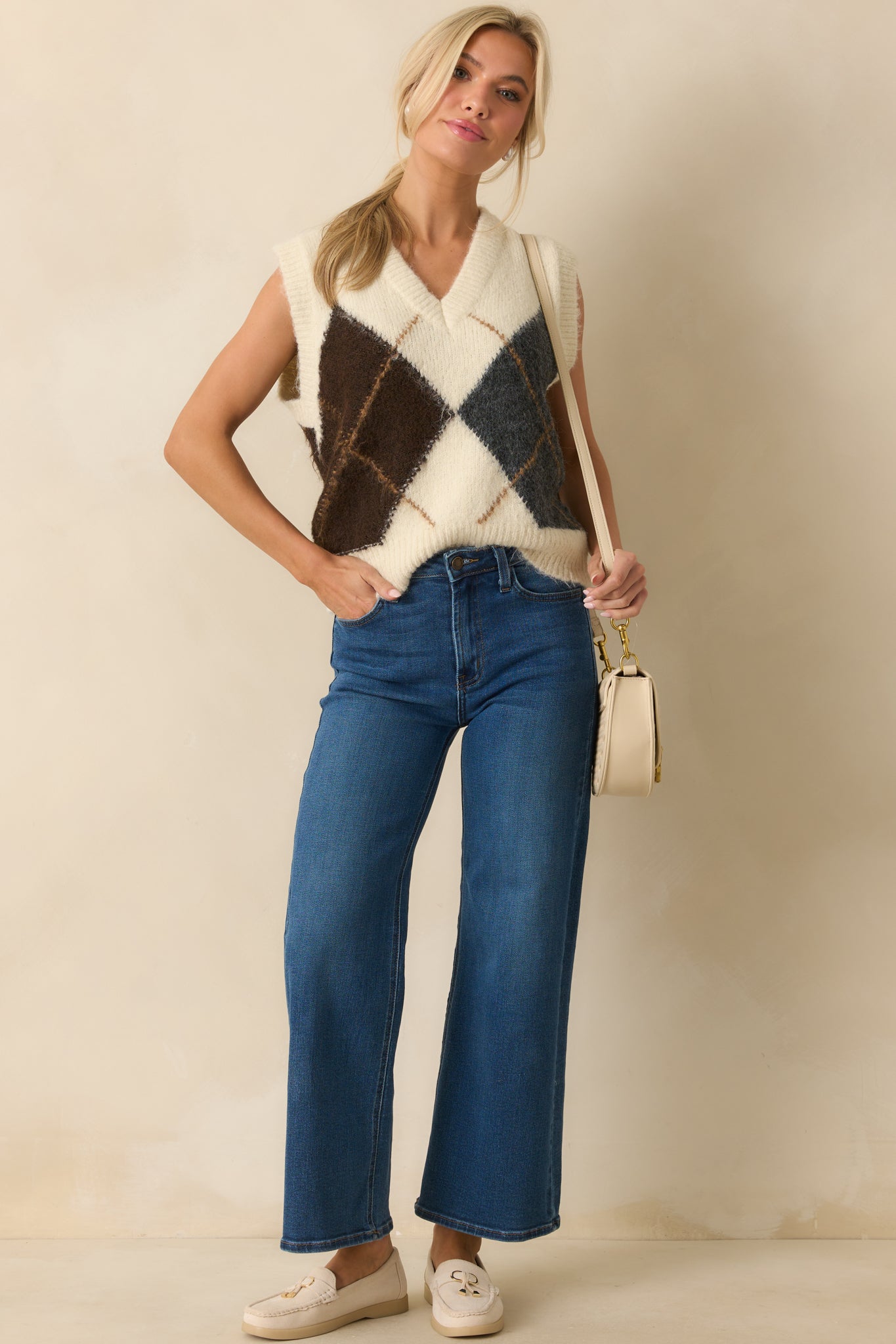 Ivory sleeveless sweater vest with a large brown and grey argyle pattern and v-neckline.