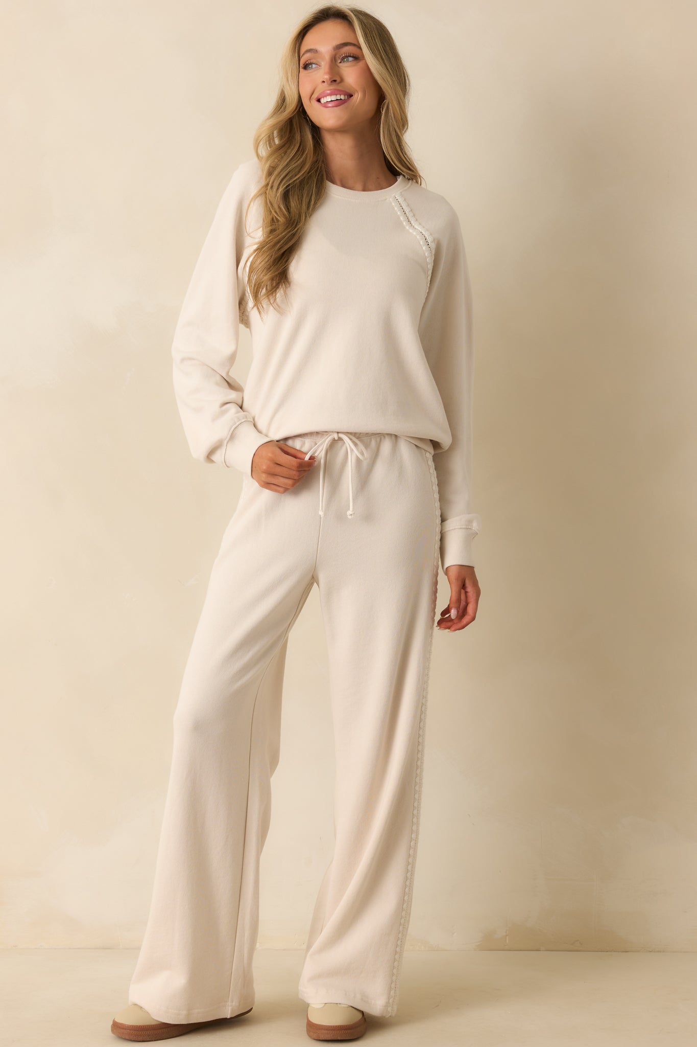 Cozy ivory sweatshirt featuring textured sleeves with crochet and embroidery details.