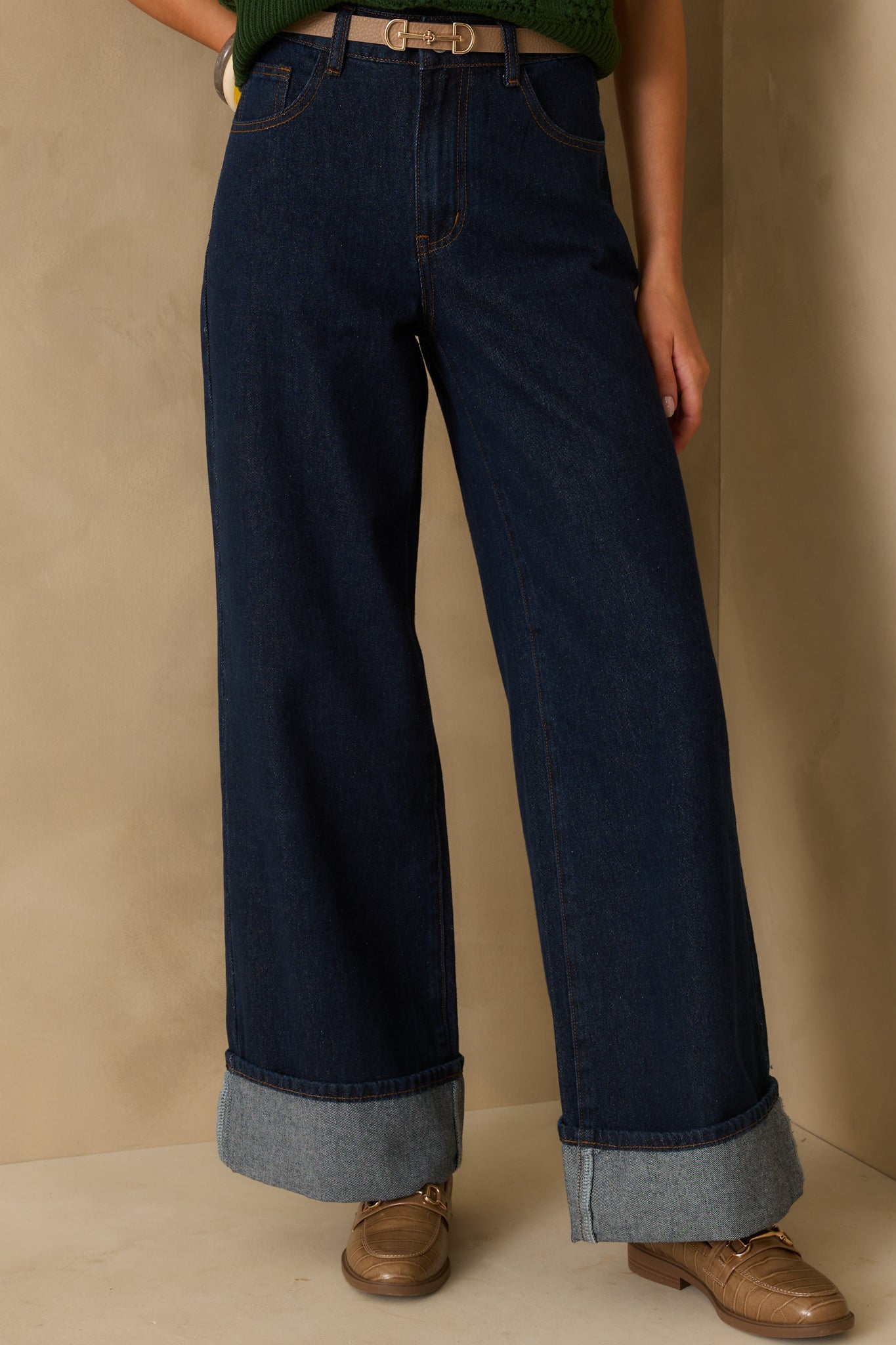 Cropped front view of the jeans from the waist focusing on the high rise and button zipper closure.