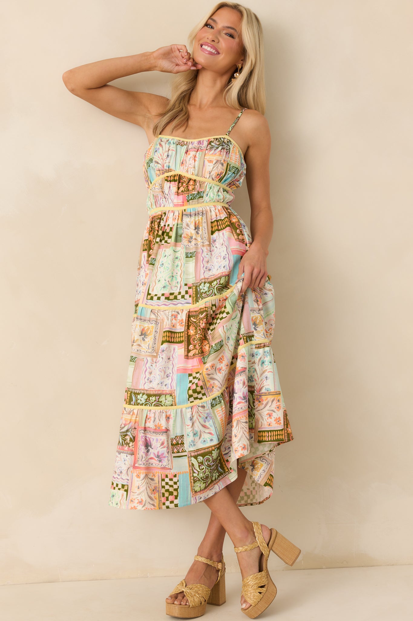 Straight-on full body shot highlighting the dress’s scoop neckline, adjustable straps, and the balanced placement of multicolor patchwork patterns across the bodice and skirt.