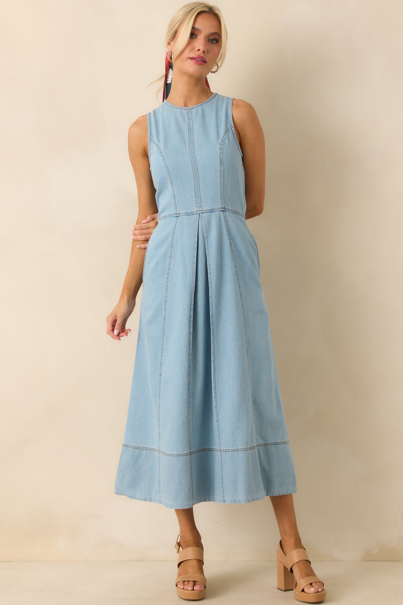 Light wash chambray midi dress with round neckline, sleeveless style, and front pleat detailing.