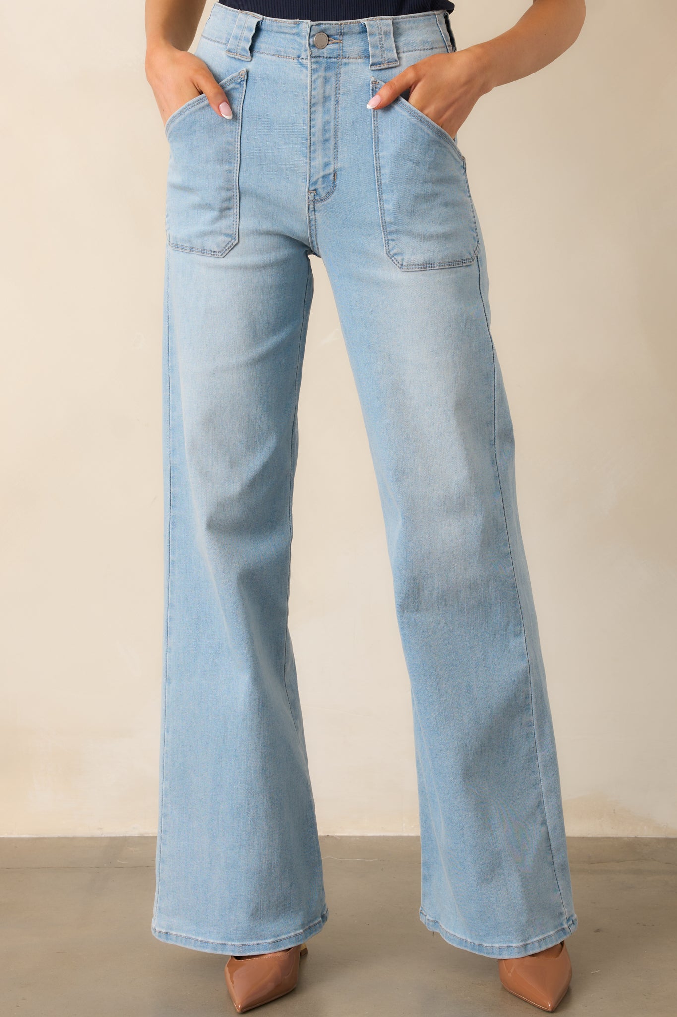 A detailed view of the light wash jeans’ flared leg, highlighting the smooth denim fabric and structured shape.