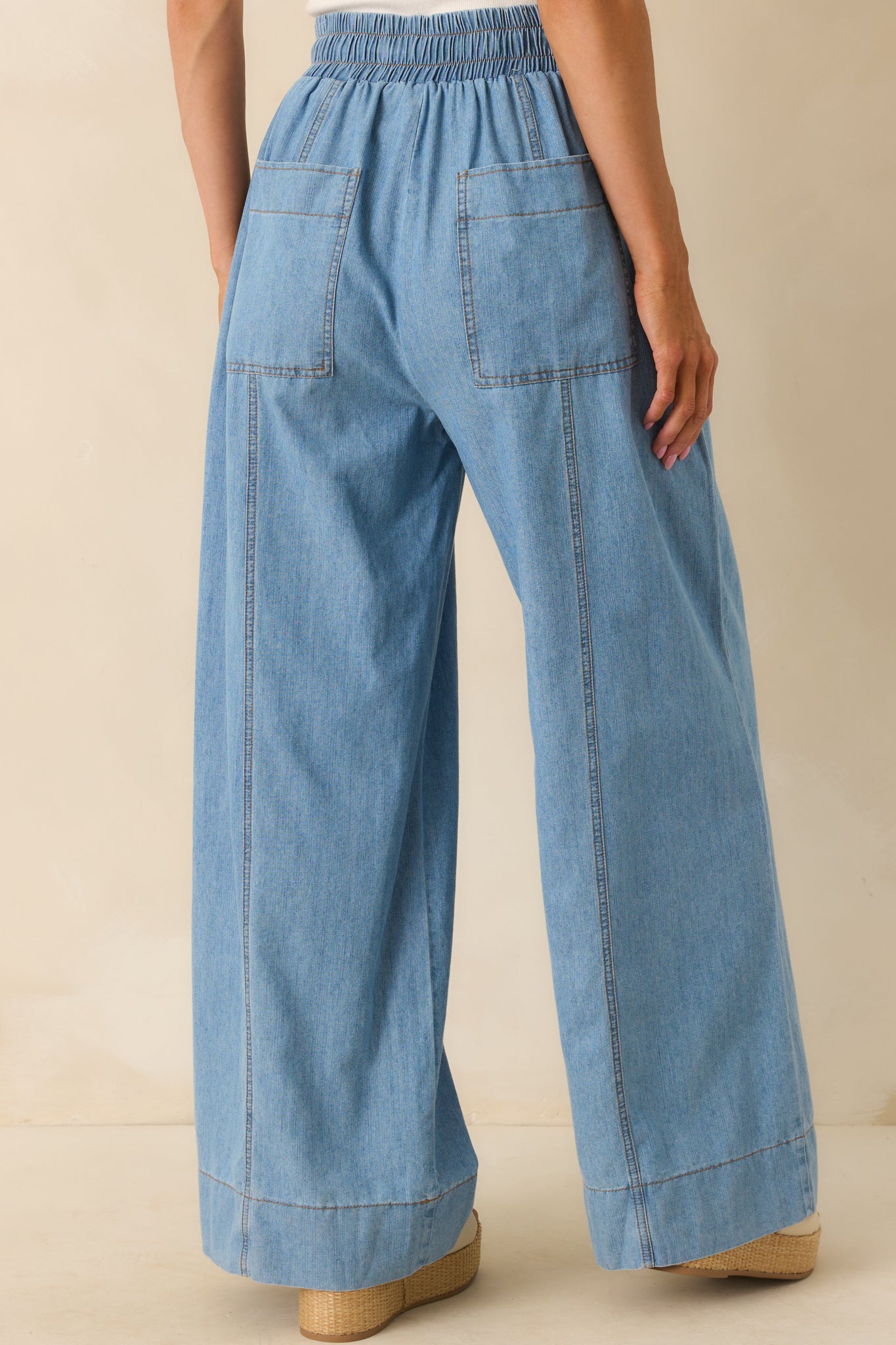 Rear view of the pants displaying the back patch pockets, high waistband, and panel seams from behind.