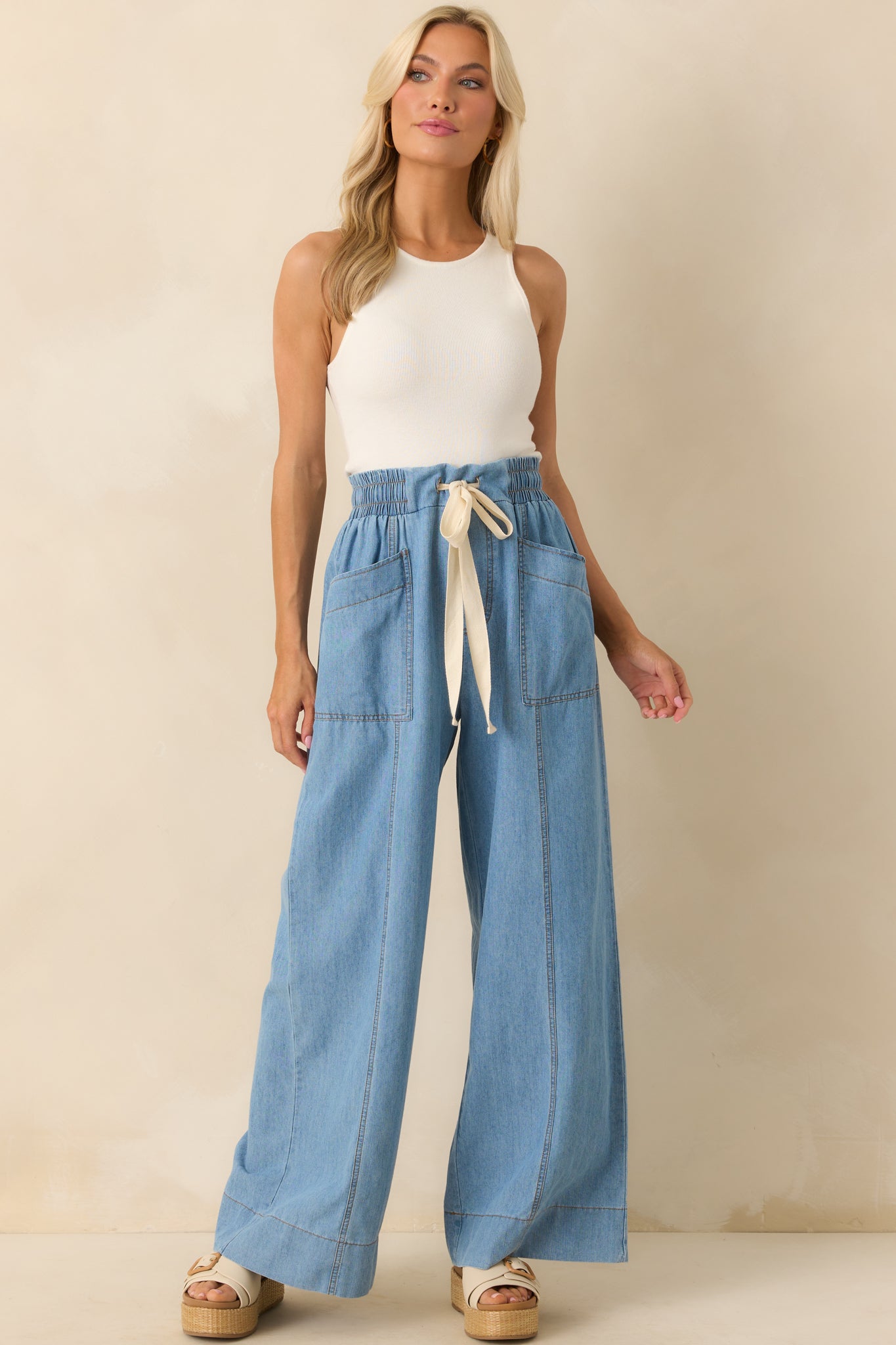 Full body shot showcasing the paneled design and ivory drawstring at the waist of the light cotton pants.