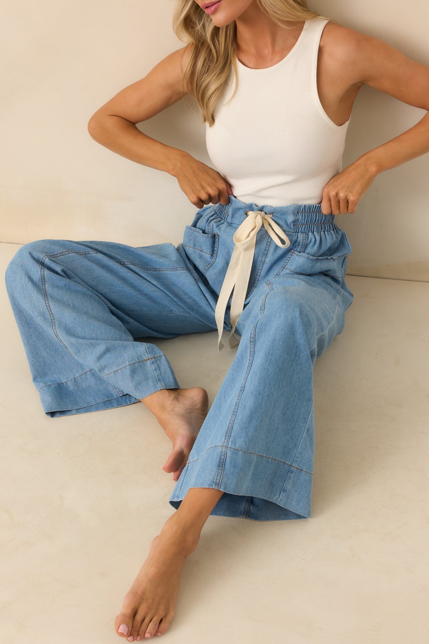 Cropped front view focusing on the waistband area with visible elastic and an ivory drawstring tied at the center.
