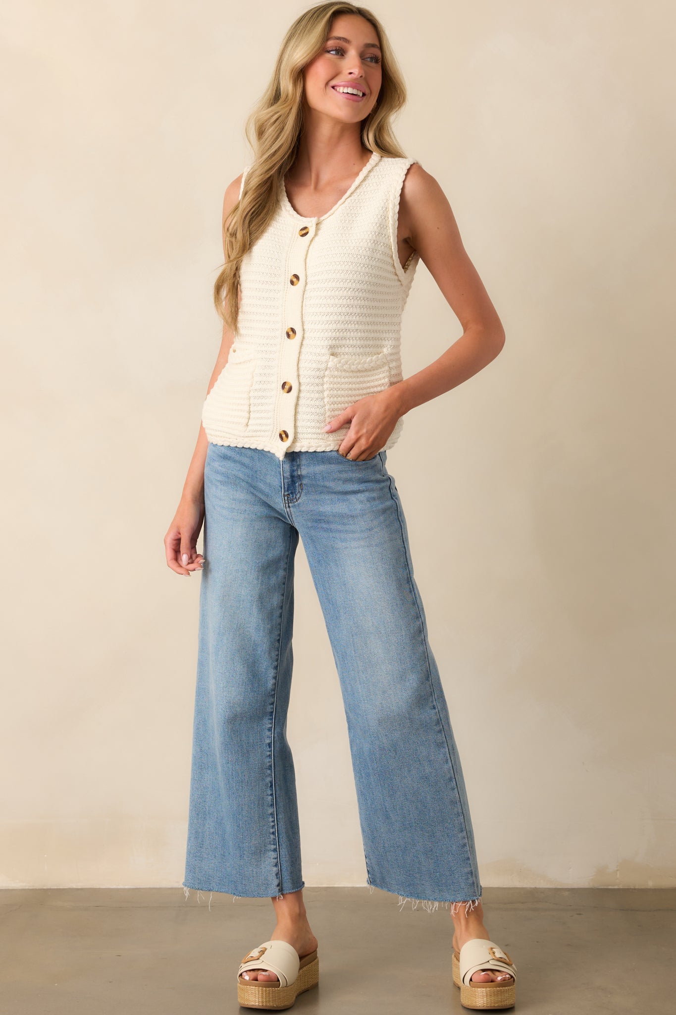 These light wash jeans feature a wide leg design with a slightly cropped length, finished with a raw bottom hem for a trendy look.