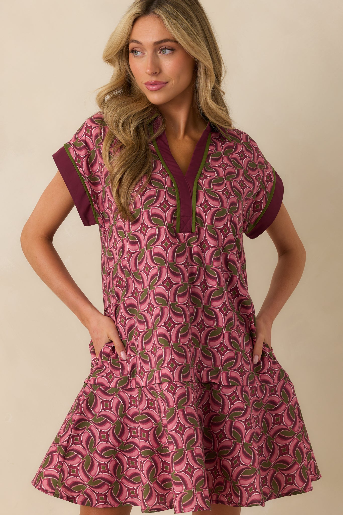Functional pocket detail hidden within the mauve patterned fabric of the dress.