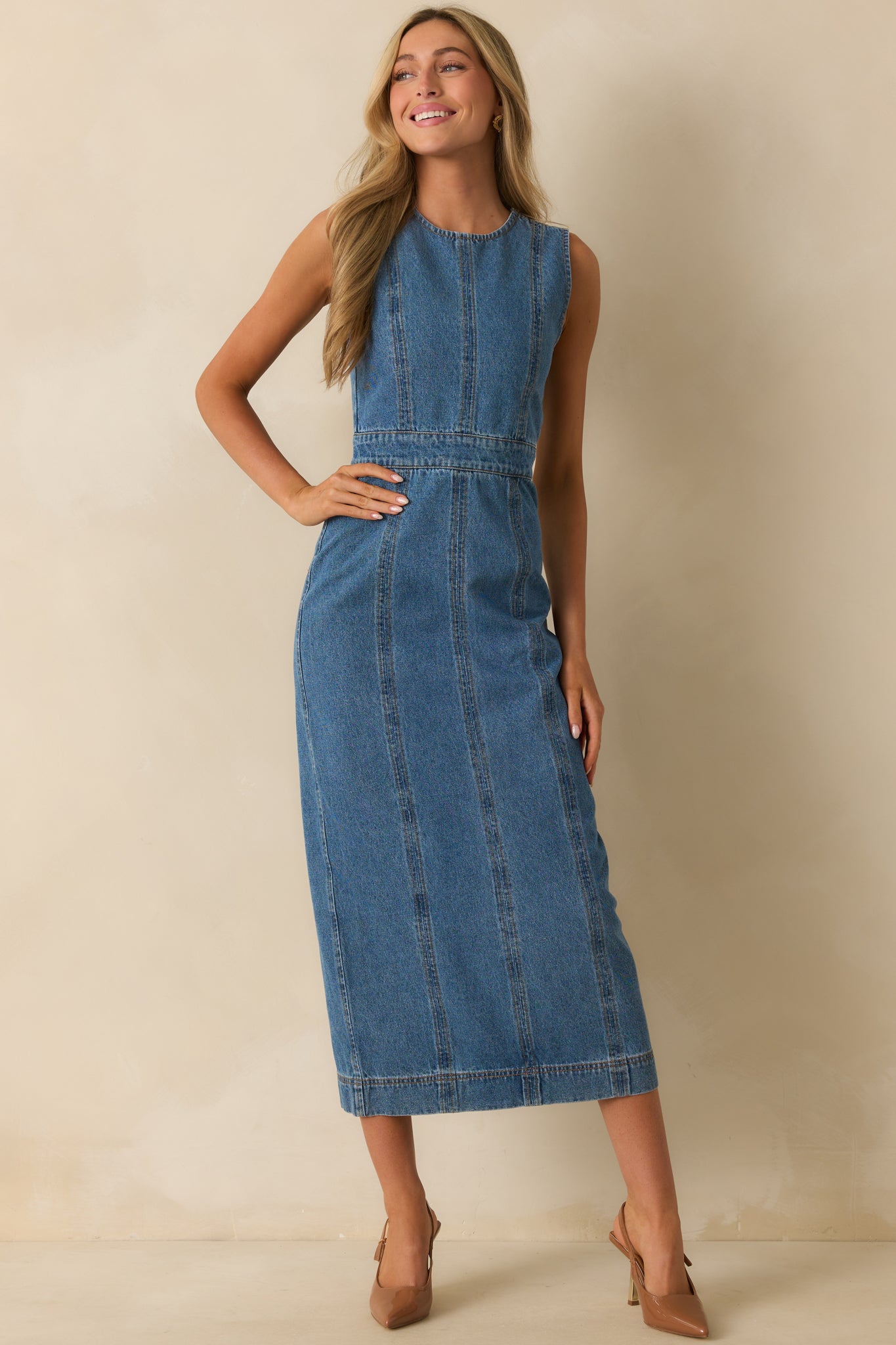 Medium wash dress with a streamlined cut and classic sleeveless design.