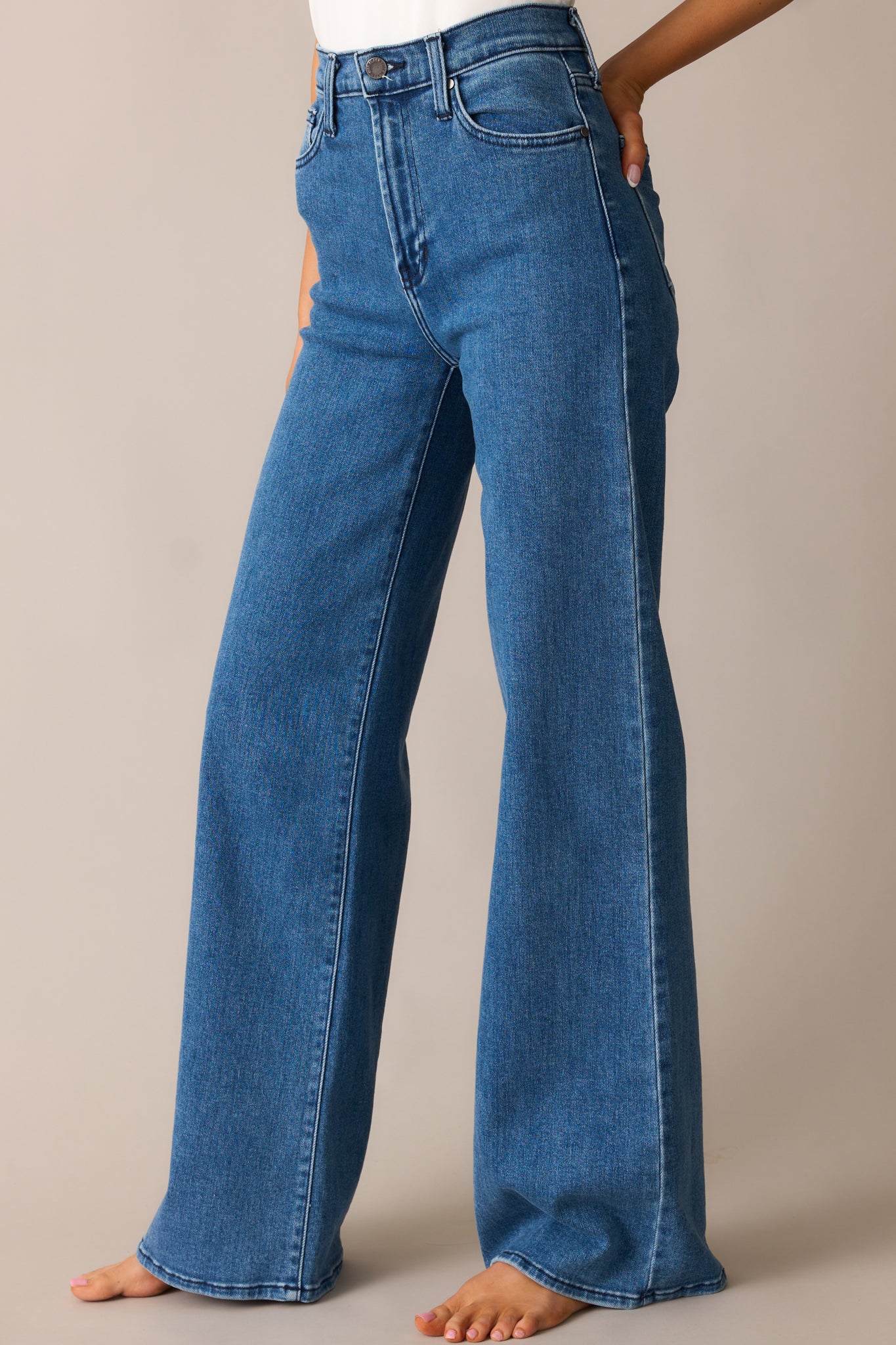 A detailed view of the jeans’ wide-leg cut, showcasing the smooth denim fabric and structured hem.