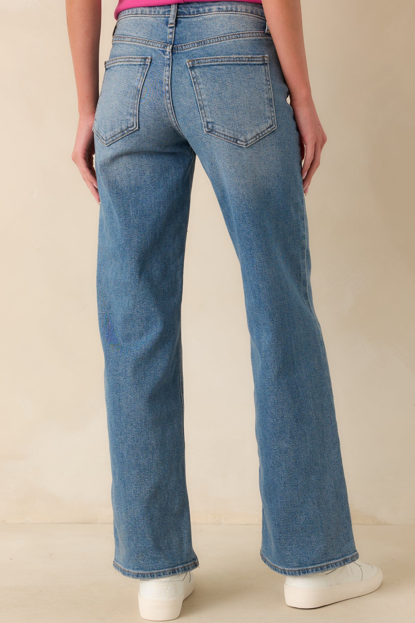 A back view of the jeans displaying the functional back pockets, belt loops, and wide leg shape from behind.
