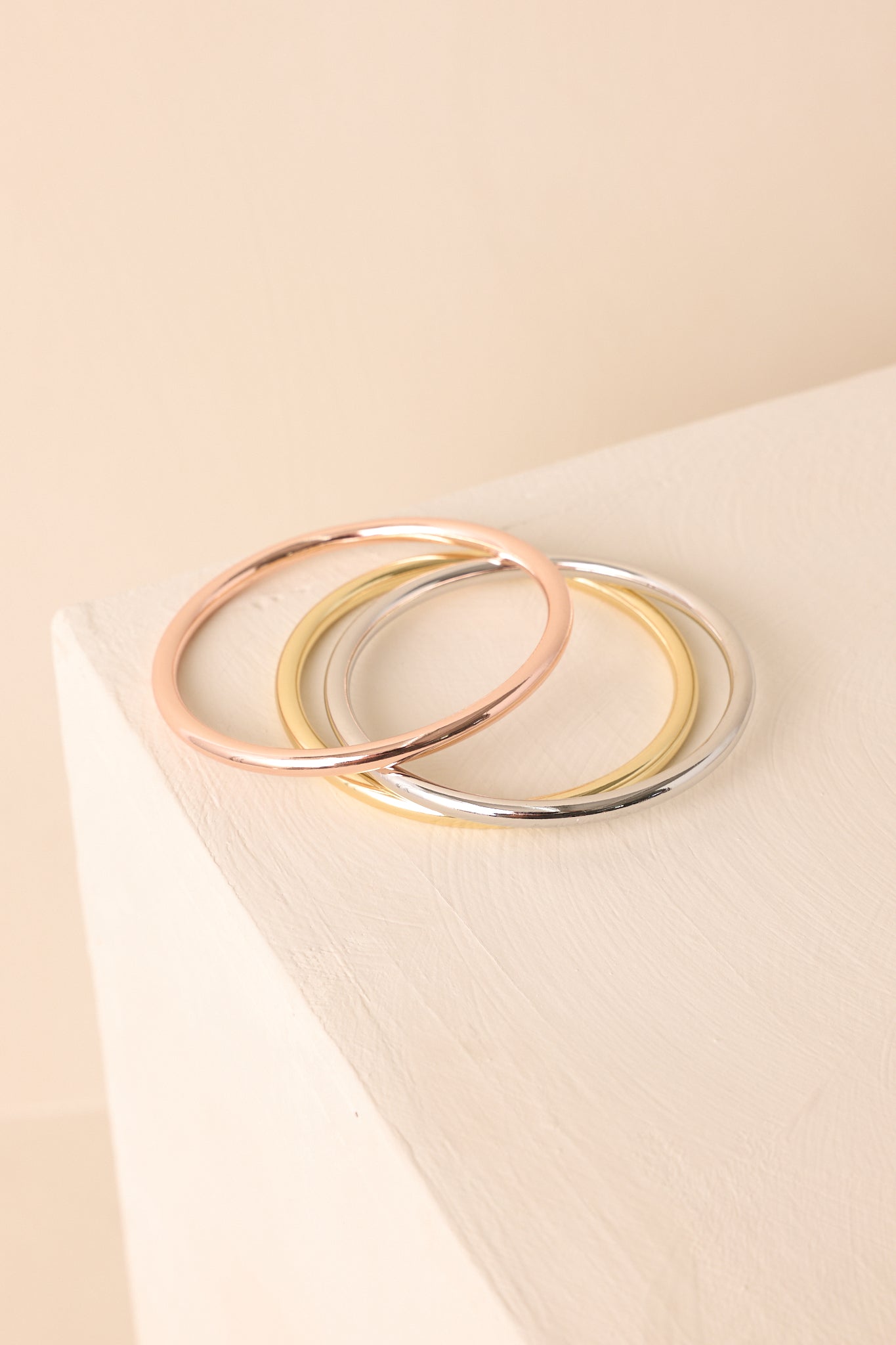 A detailed shot of metal-tone bangles showing a polished surface and rigid round design.