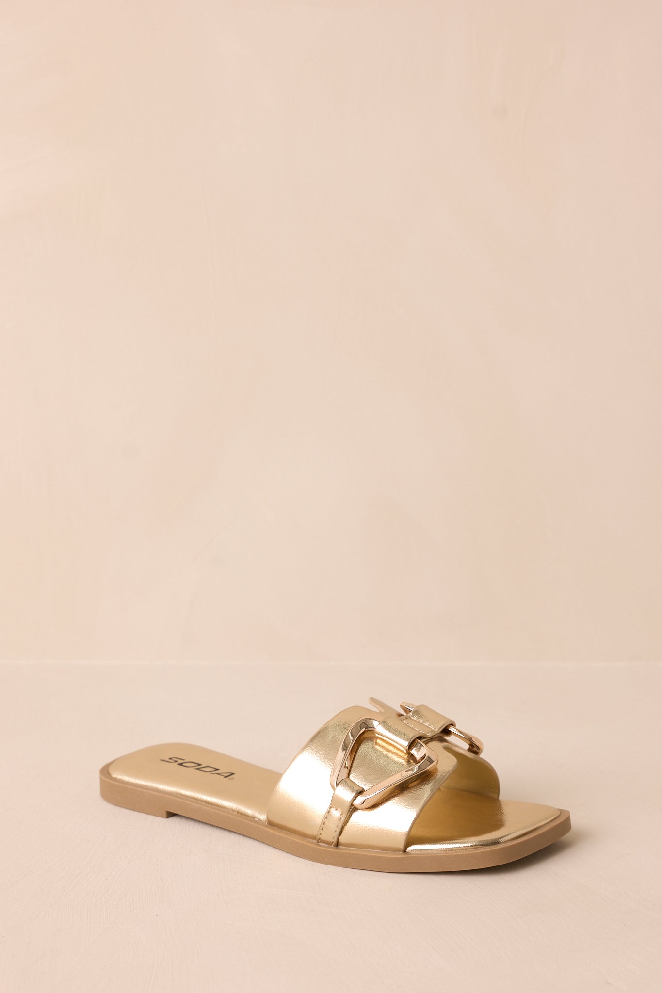 A dynamic shot showing the slip-on design, gold buckle, and notched band from a slightly angled perspective.