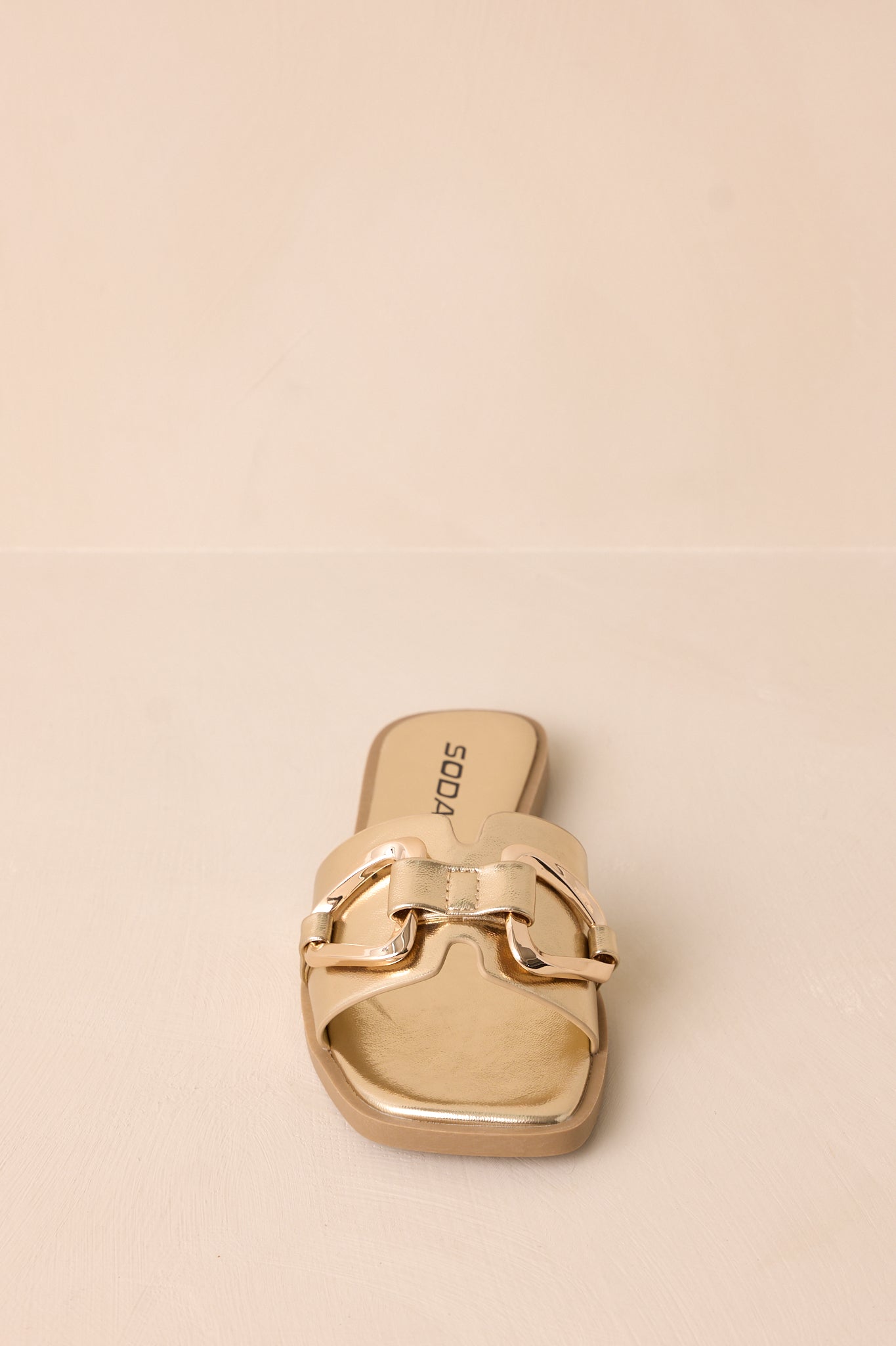 A dynamic shot showing the slip-on design, gold buckle, and notched band from a slightly angled perspective.