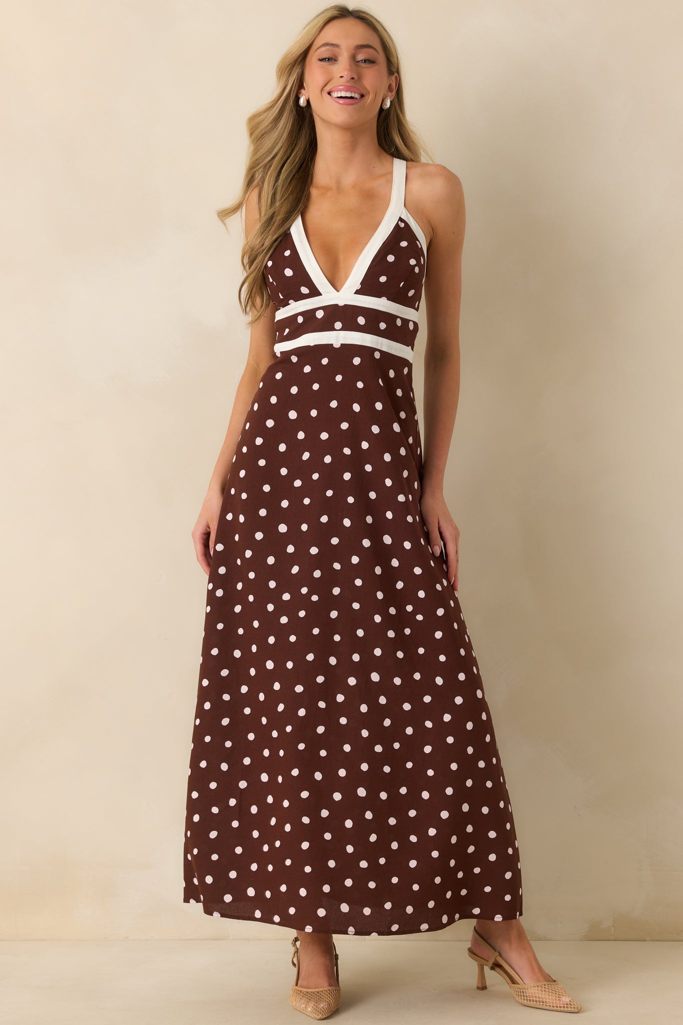 Front-facing view of the chocolate brown maxi dress showing ivory polka dot print, deep v-neckline with white contrast trim, and flowing maxi silhouette with elastic back details.