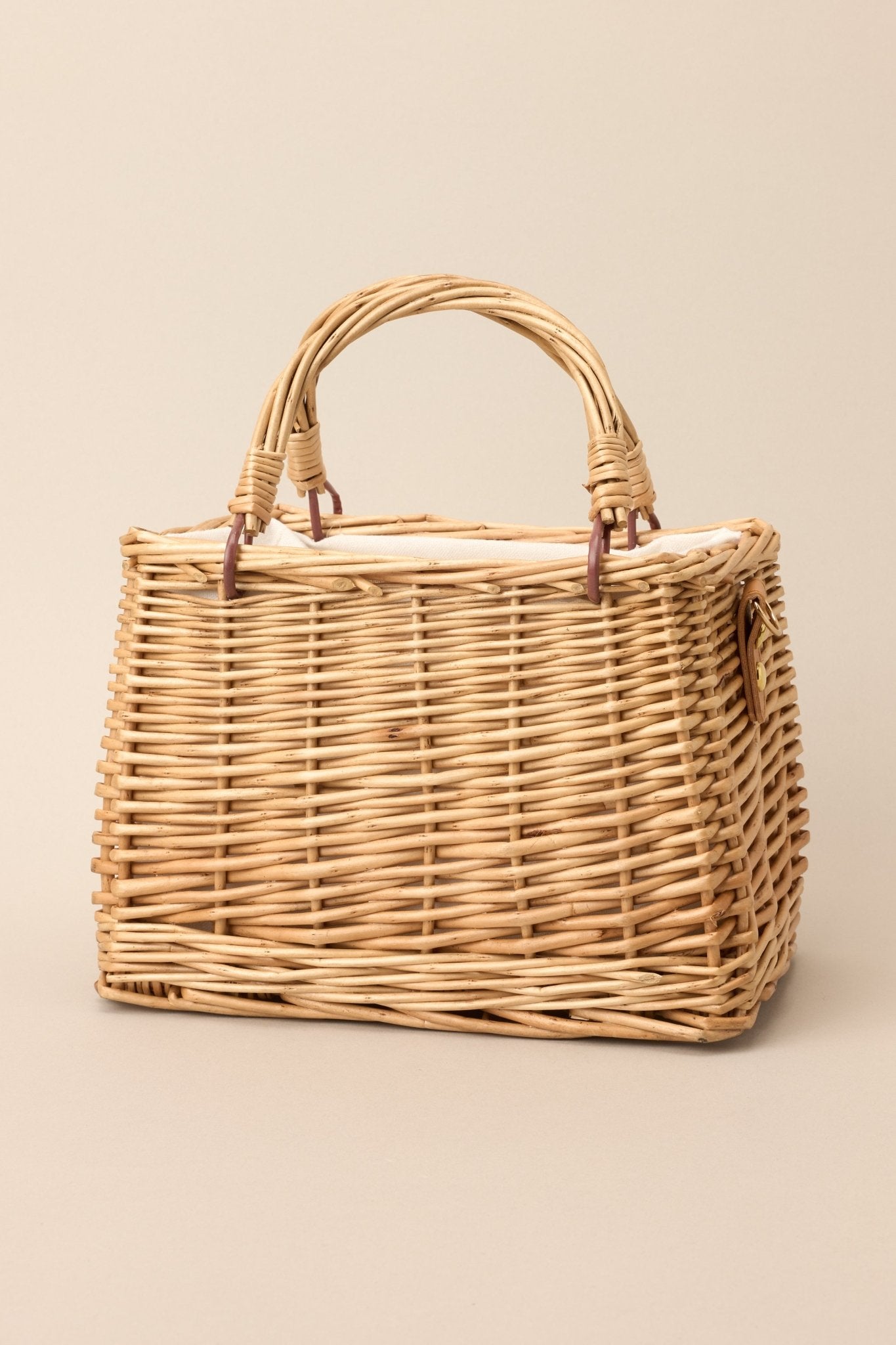 Close view of the wicker-like texture and functional top handles on the handbag, highlighting the woven pattern and structured shape.