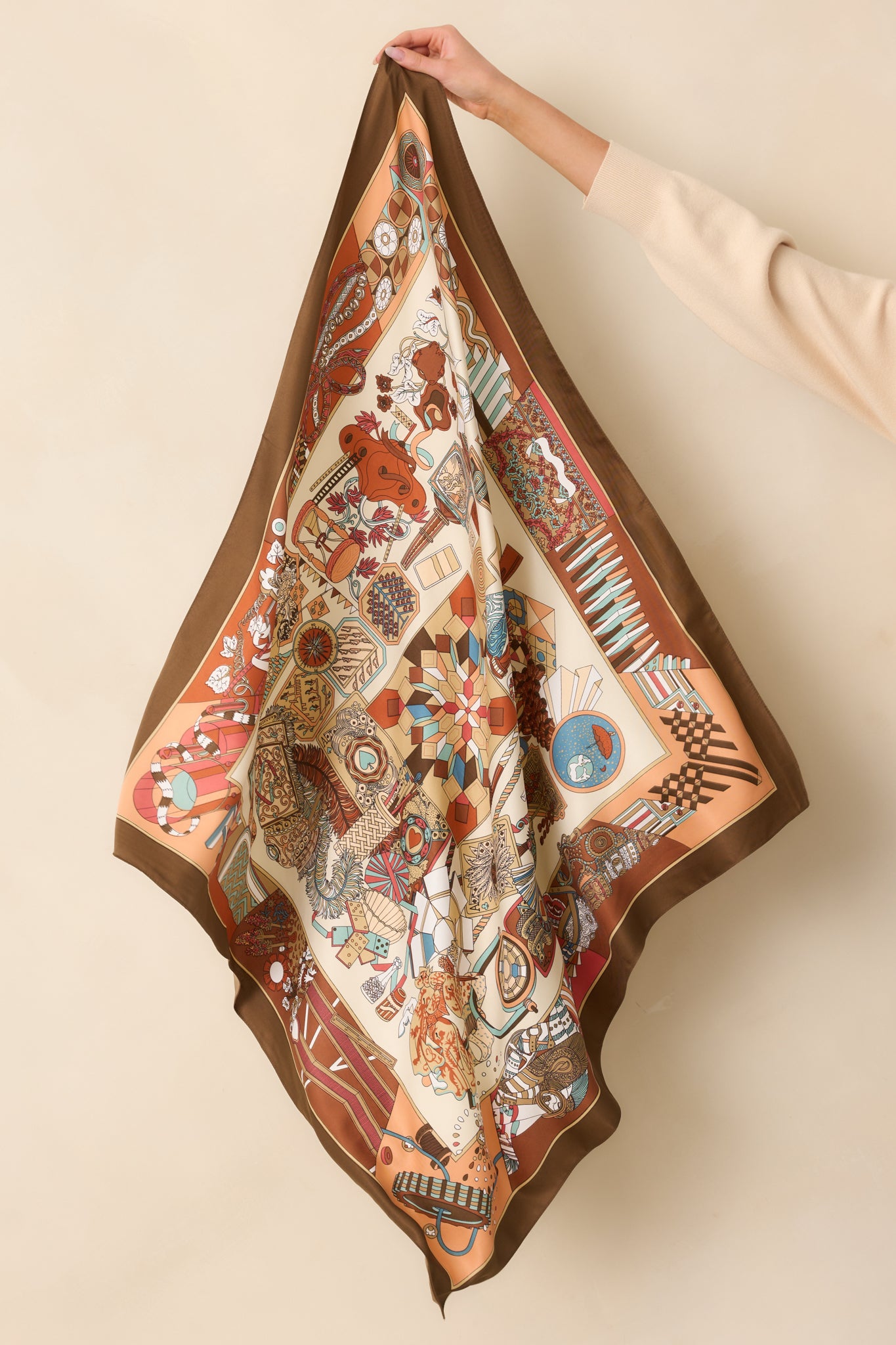 Flat view of the scarf fully spread out, showing the large square shape, brown multicolor prints, and varied motifs across the satin surface.