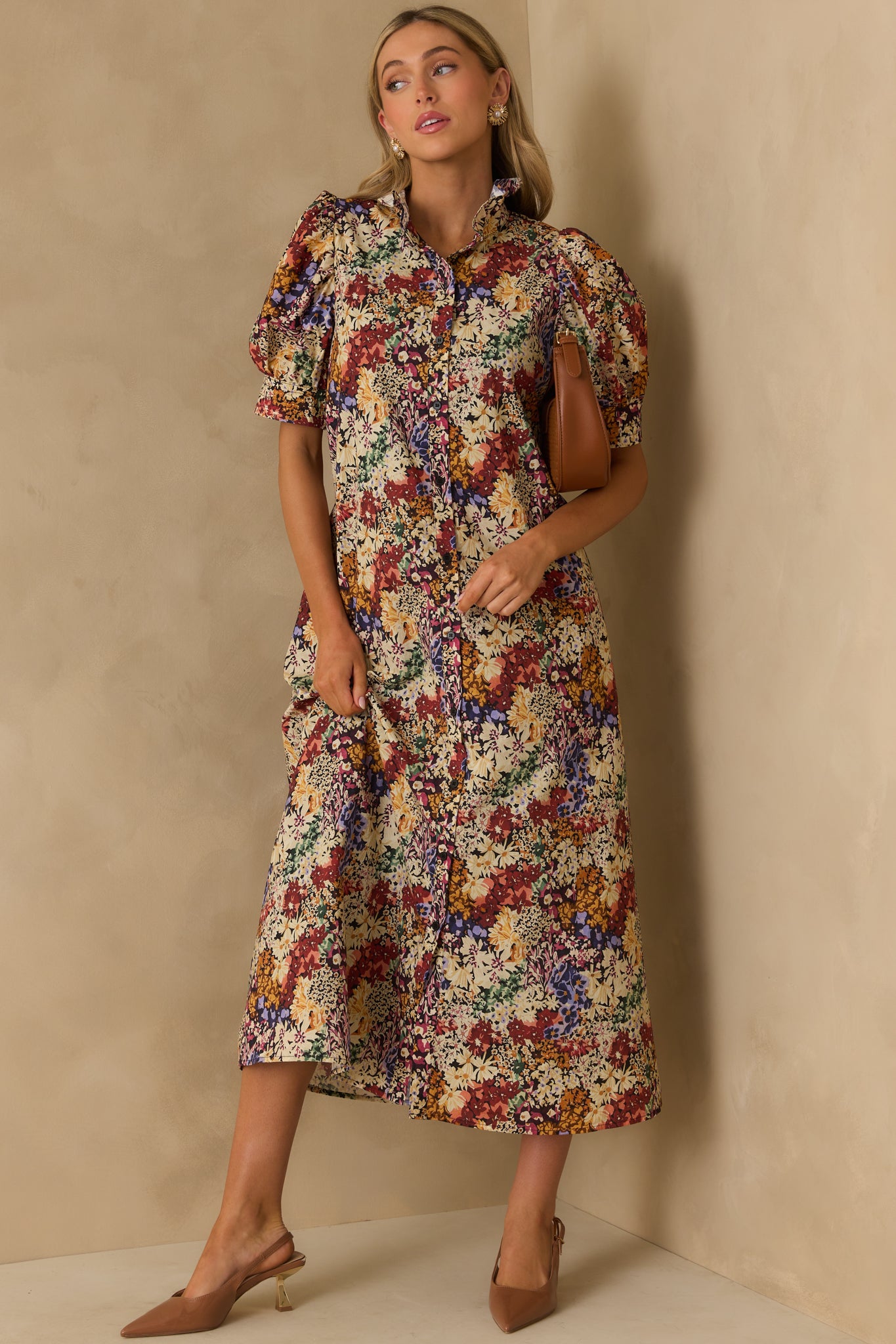 Maxi dress featuring an allover multicolor floral design, ruffle neckline, and structured black stitch details.