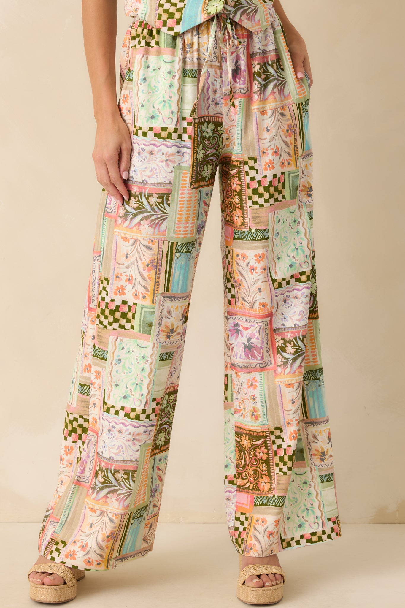Cropped shot focusing on one leg of the pants, highlighting the patchwork pattern and wide leg cut.