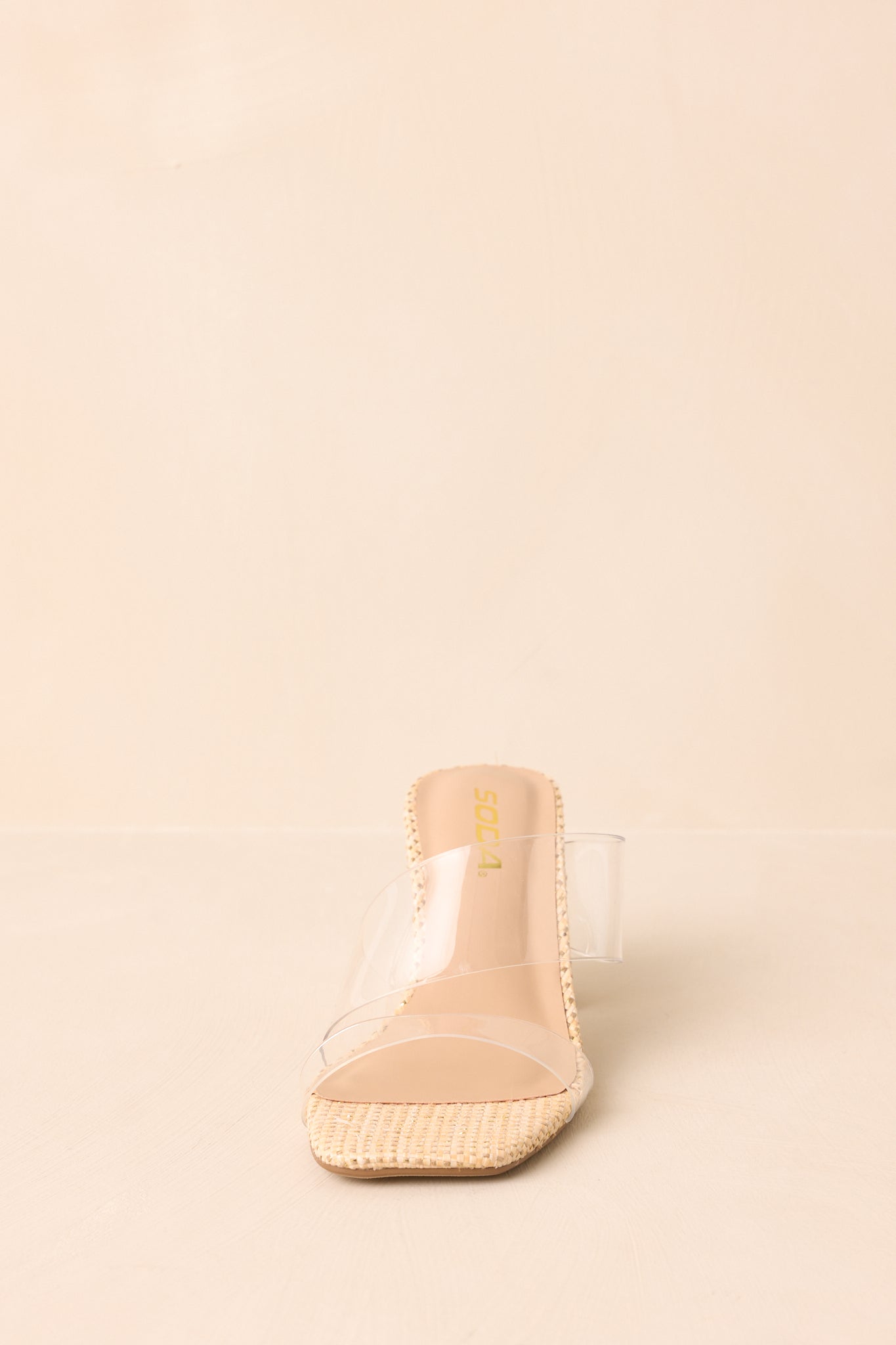 Front-facing view of raffia heels highlighting transparent straps.