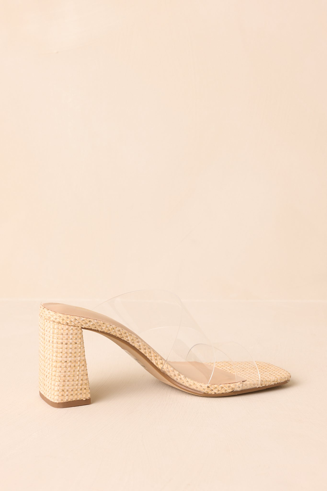 Low-angle view of raffia heels showing block heel shape and raffia texture.
