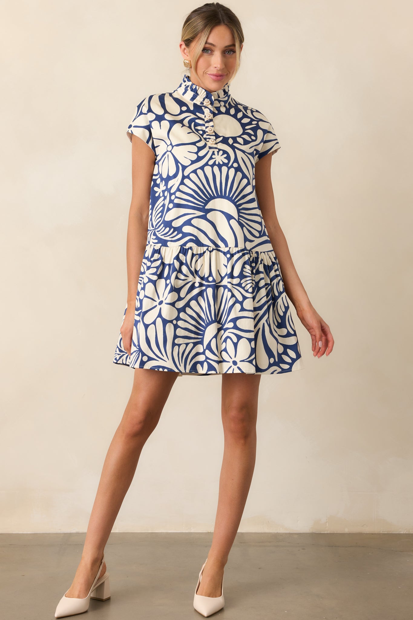 A front view of the mini dress showing the ruffle mock neckline and functional flower button front.