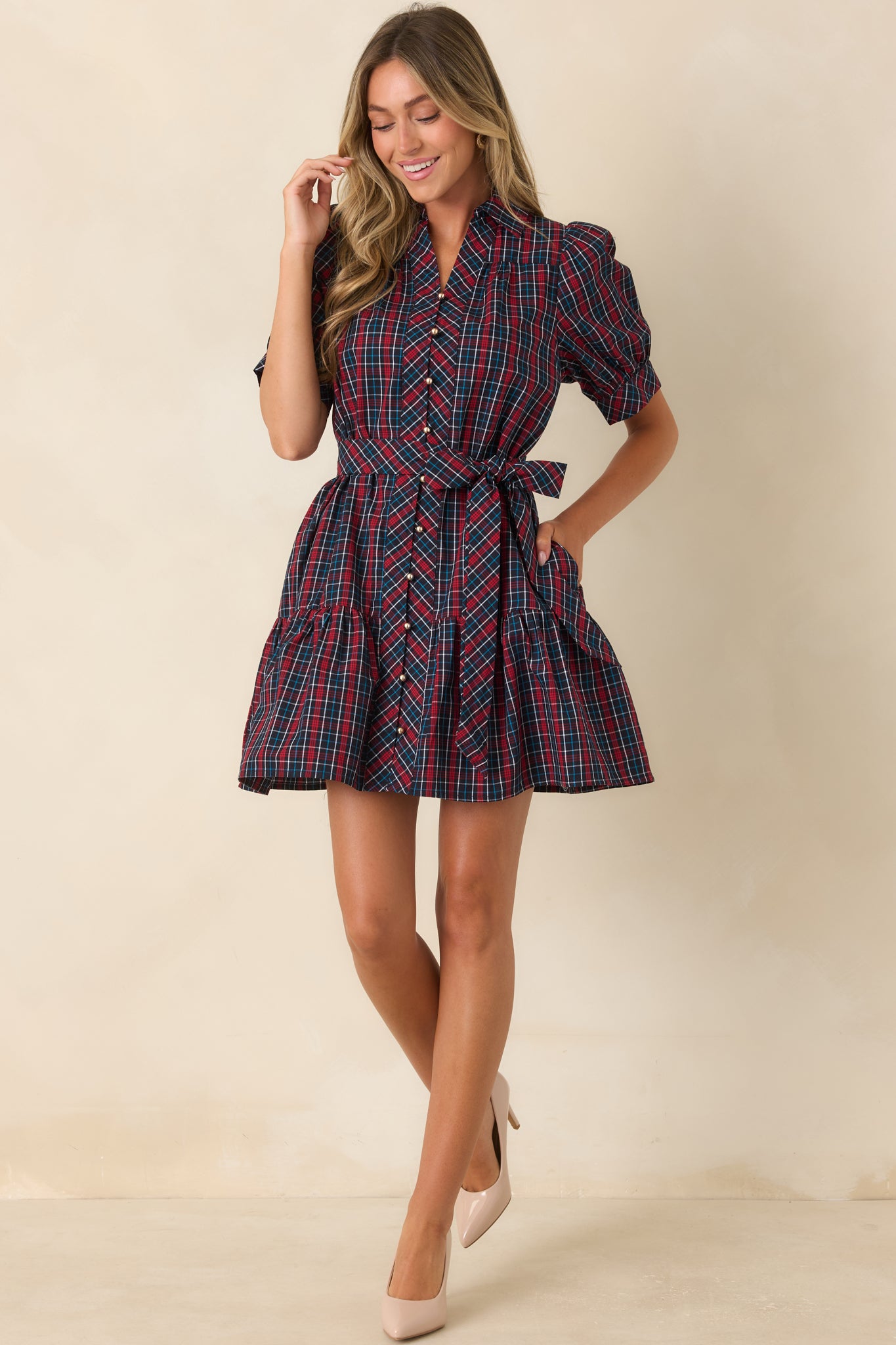 Navy and red plaid button-front mini dress with puff sleeves, waist tie, and tiered skirt.