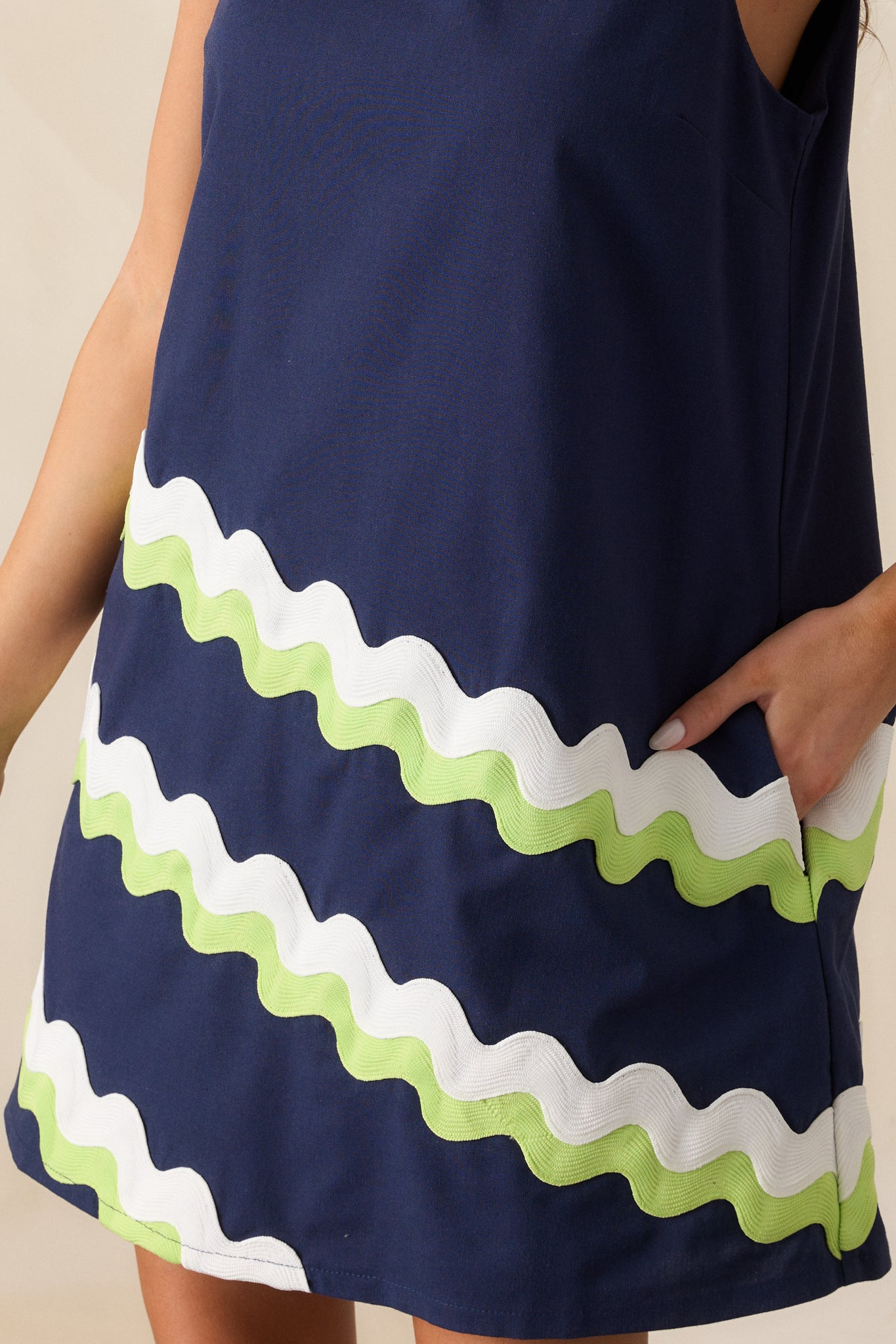 Fabric detail featuring lime green and white ricrac stripes on navy fabric with visible stitching and texture.