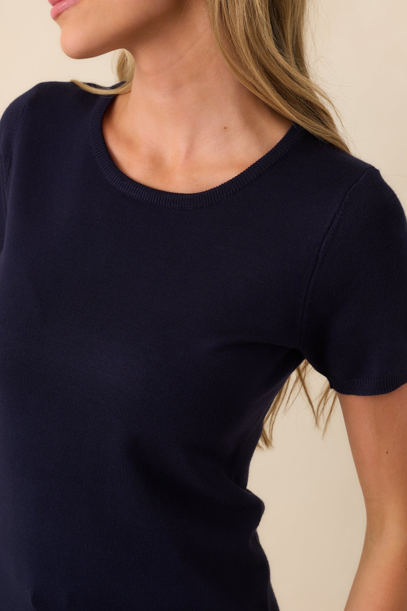 A detailed shot of the navy sweater top showing the fine knit texture and ribbed edging.