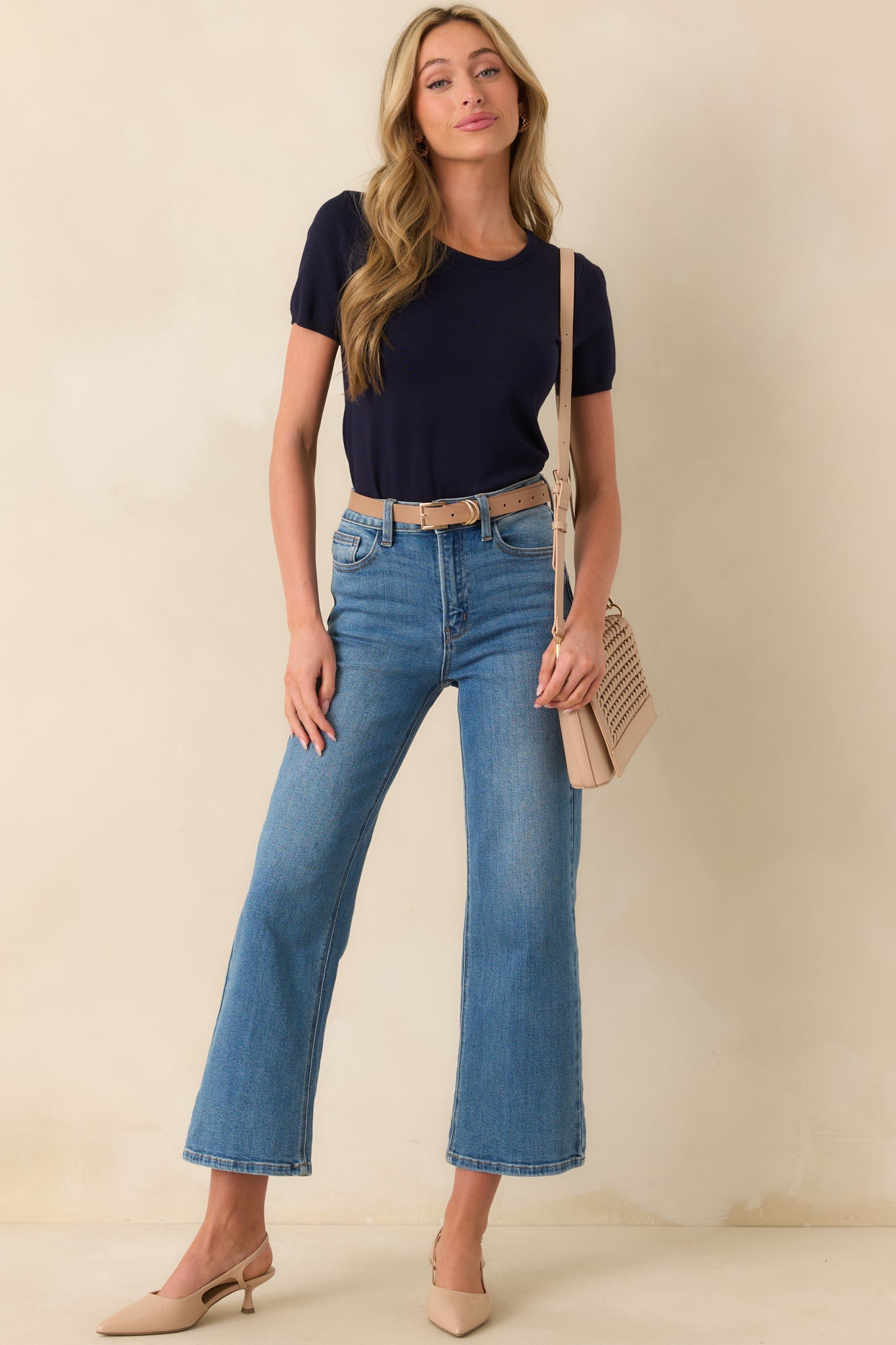 A full length shot emphasizing the casual fit and clean lines of the navy sweater top.