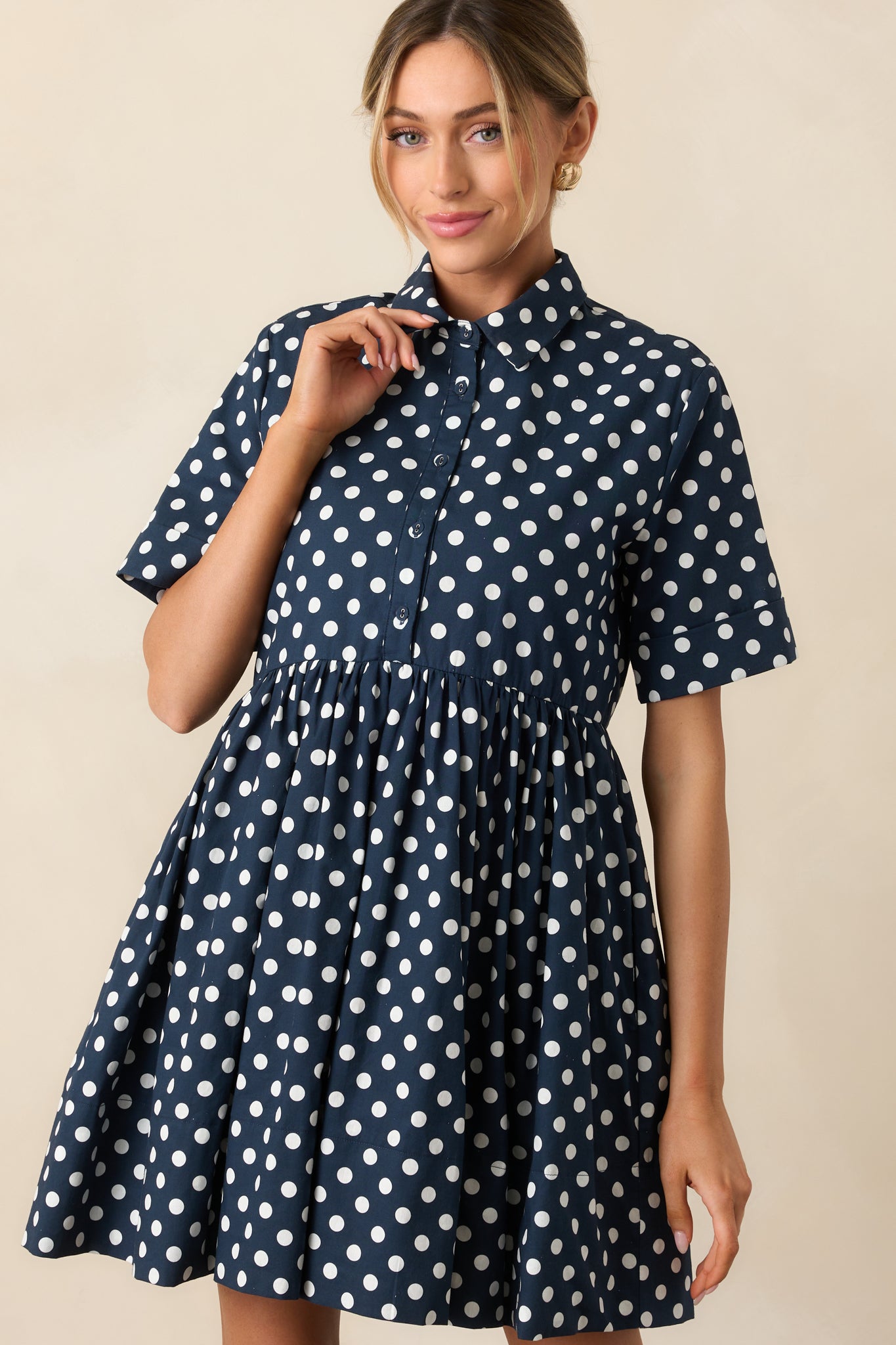 Cropped image focusing on waistline and button placket of polka dot dress.