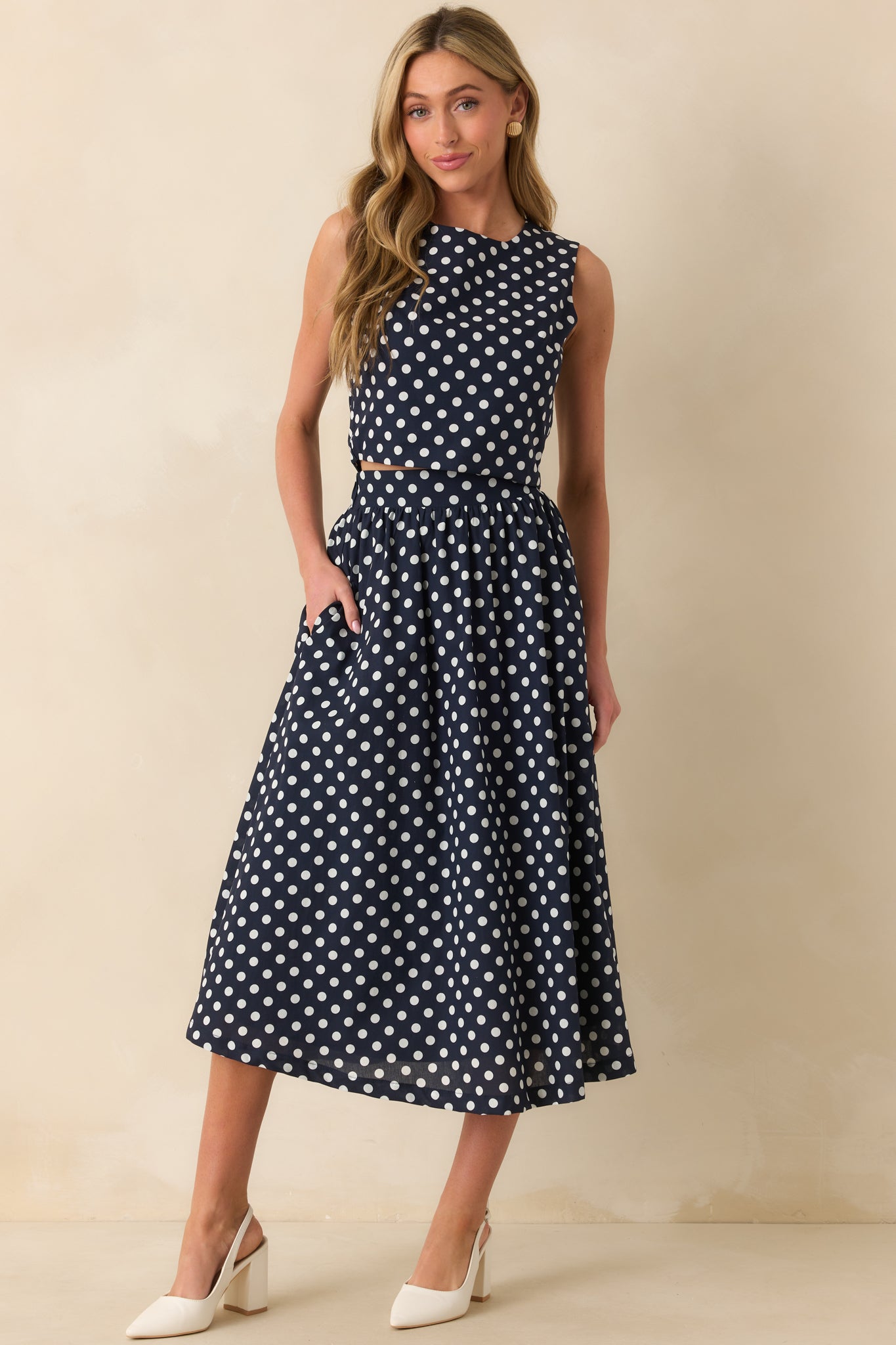 Front view of fitted polka dot crop top with round neckline.